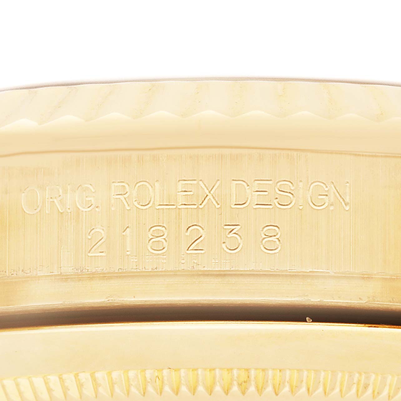 The image shows an engraving on the side of a Rolex President 218238 Men's Yellow Gold White Dial model watch with "ORIG. ROLEX DESIGN 218238" on the case's edge.