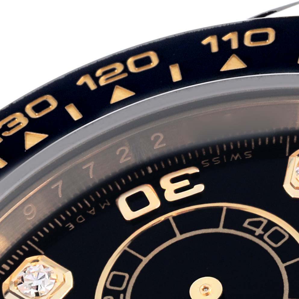 The image shows a close-up of the bezel and dial of a Rolex Daytona 116518 Men
s Yellow Gold Black Dial 116518 Men
s Yellow Gold Black Dial watch, highlighting the tachymetric scale and part of the face.