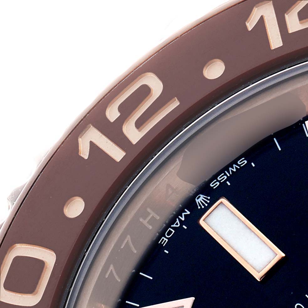 The image shows a close-up of the Rolex GMT-Master 126715 Men's Rose Gold Black Dial watch's bezel and part of the dial.