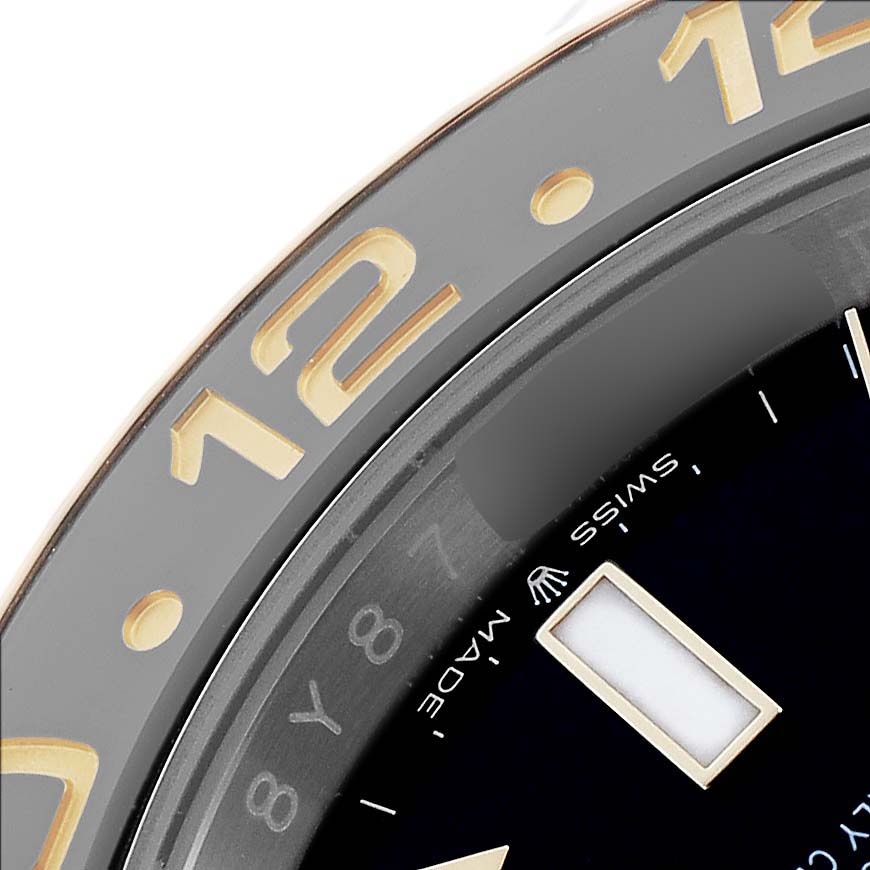 The close-up image of the Rolex GMT-Master 126713 Men's Steel and Gold (two tone) Black Dial watch shows part of the bezel with numerals and a portion of the dial.