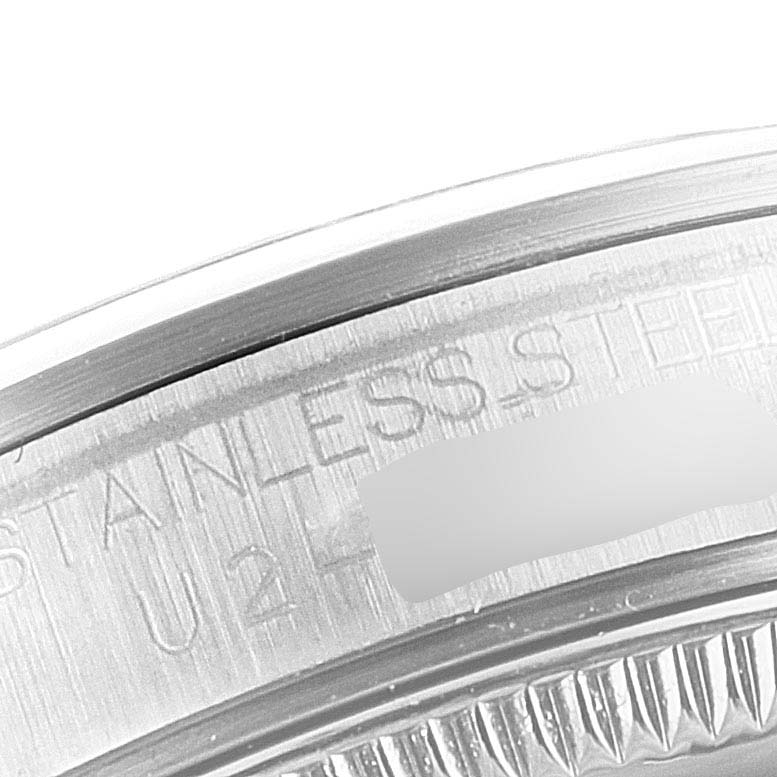The image shows a close-up of the back case edge of a mid-size Rolex watch, highlighting the "STAINLESS STEEL" engraving.