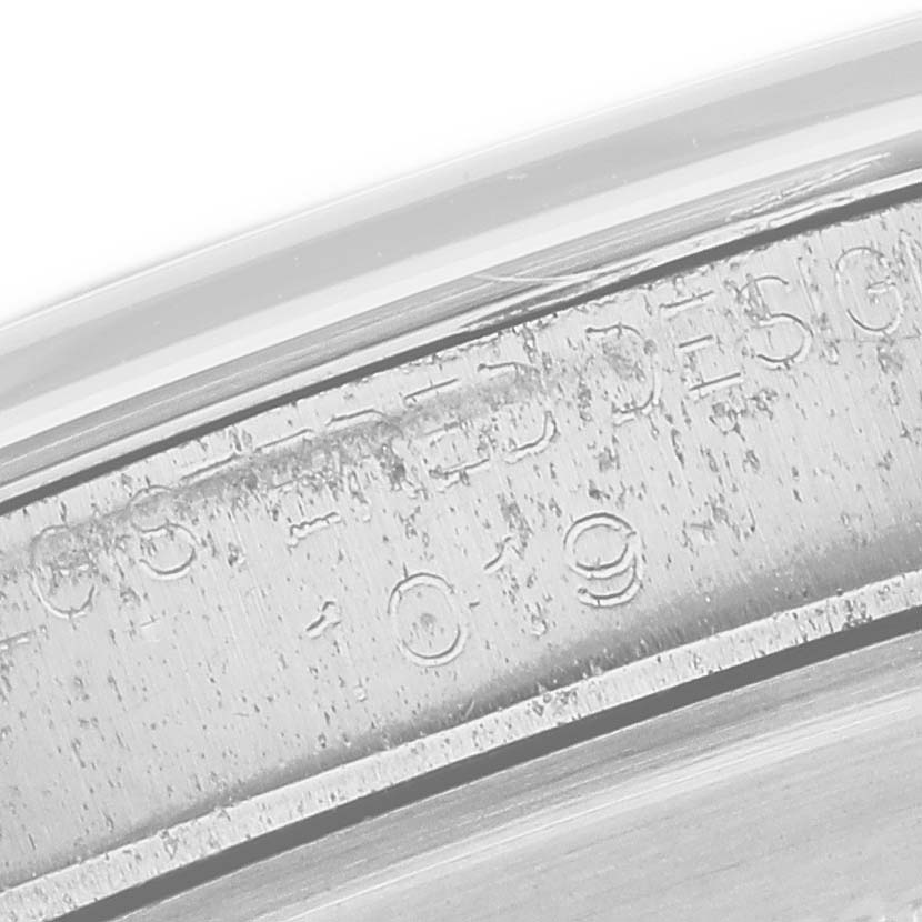 The image shows a close-up of the engraved edge on a Rolex Vintage Collection 1019 Men's Stainless Steel Black Dial watch.