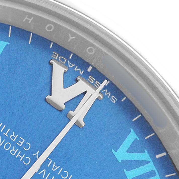 The image shows a close-up of the blue dial, Roman numerals, and minute hand of a Mid-Size Rolex watch.