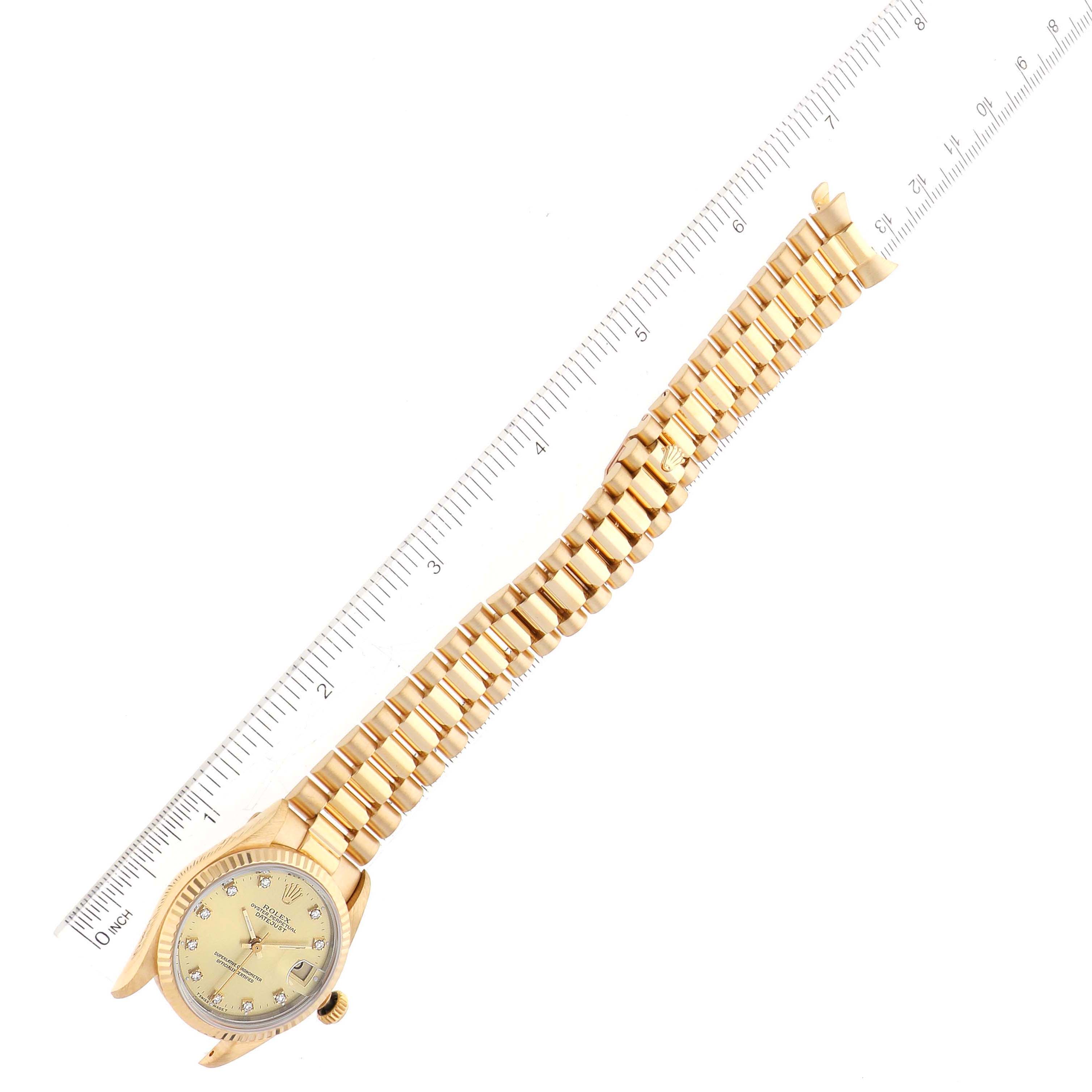 The image shows a Rolex President 68278 Women's Yellow Gold Black Dial 68278 Women's Yellow Gold Black Dial watch from an angled top-down view, highlighting the face, bracelet, and clasp with a measuring ruler alongside.