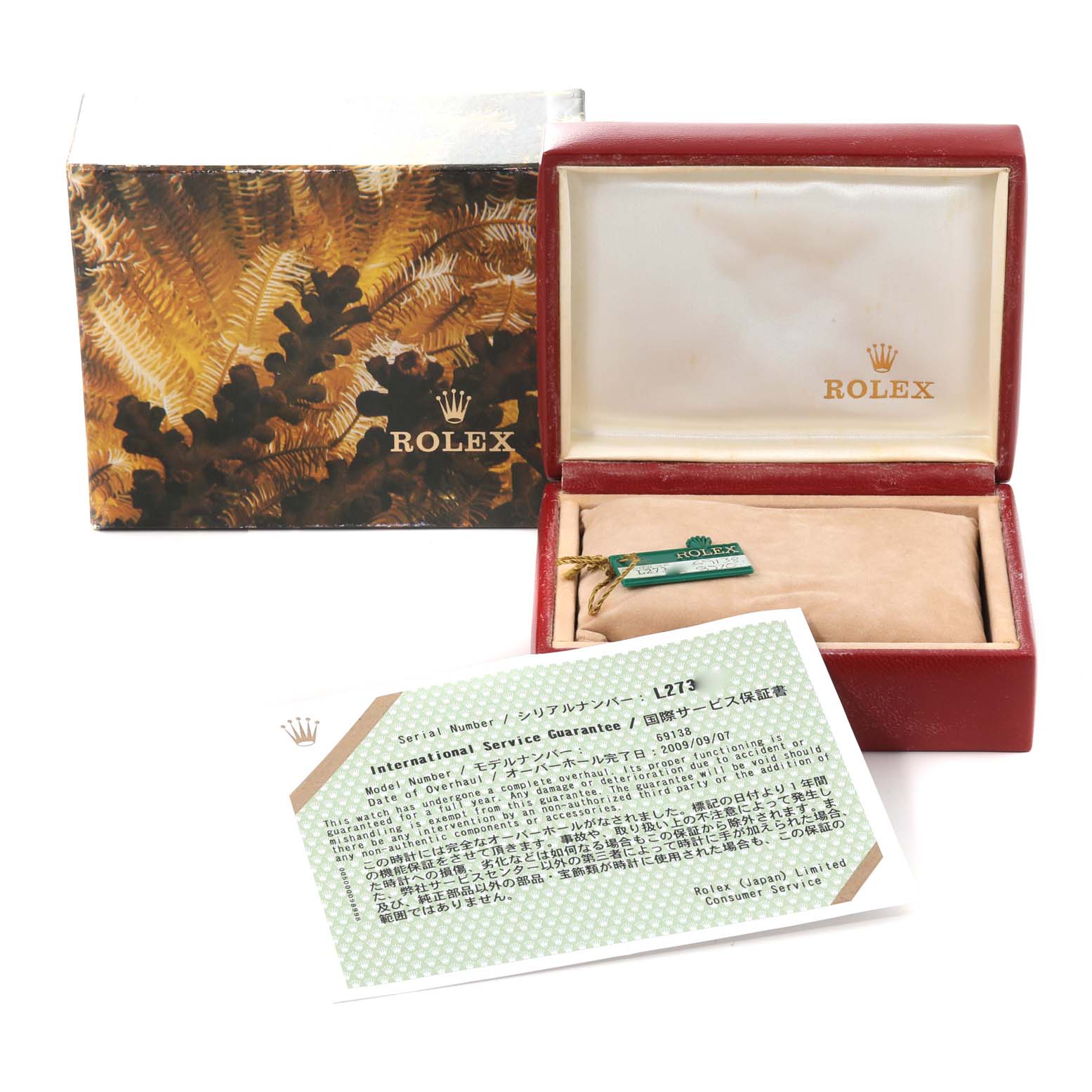 The image shows the accessories for a Rolex President 69138G Women
s Yellow Gold Champagne Dial 69138G Women
s Yellow Gold Champagne Dial model, including a box, international service guarantee, and a tag.