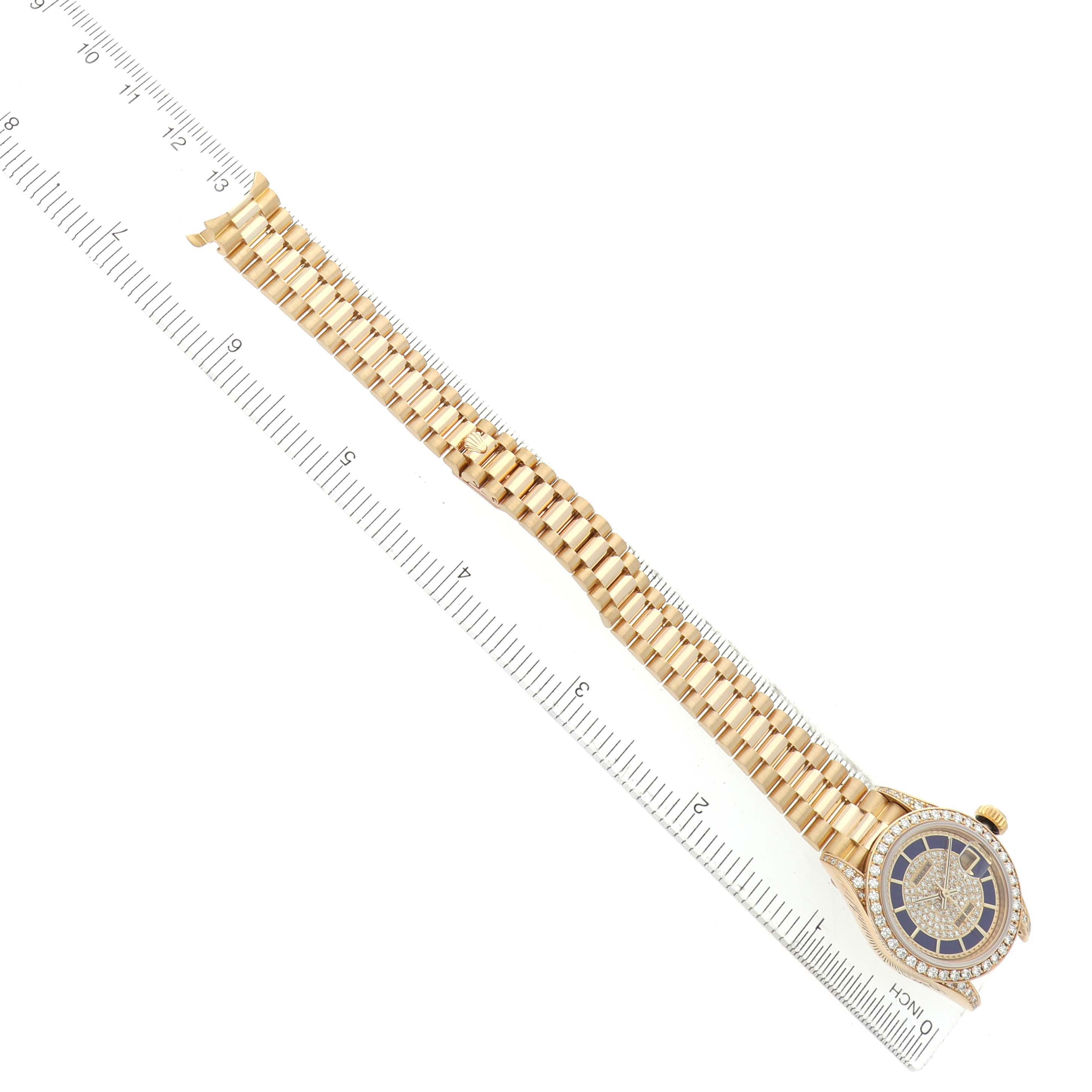 The Rolex President 69158 Women's Yellow Gold Champagne Dial watch is shown from an overhead angle, displaying the bracelet and face, with a ruler alongside for scale.
