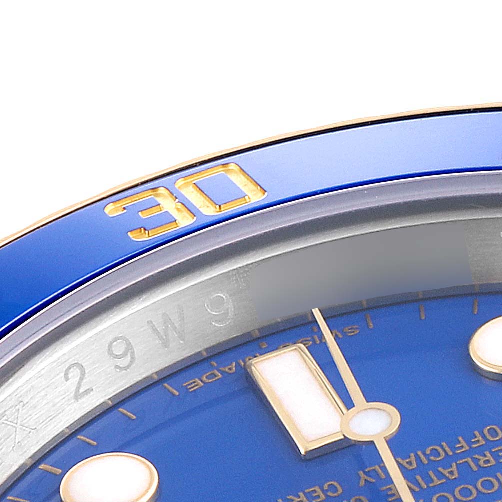 This close-up shows the bezel and part of the dial of a Rolex Submariner 116613 Men's Steel and Gold (two tone) Blue Dial 116613 Men's Steel and Gold (two tone) Blue Dial watch.