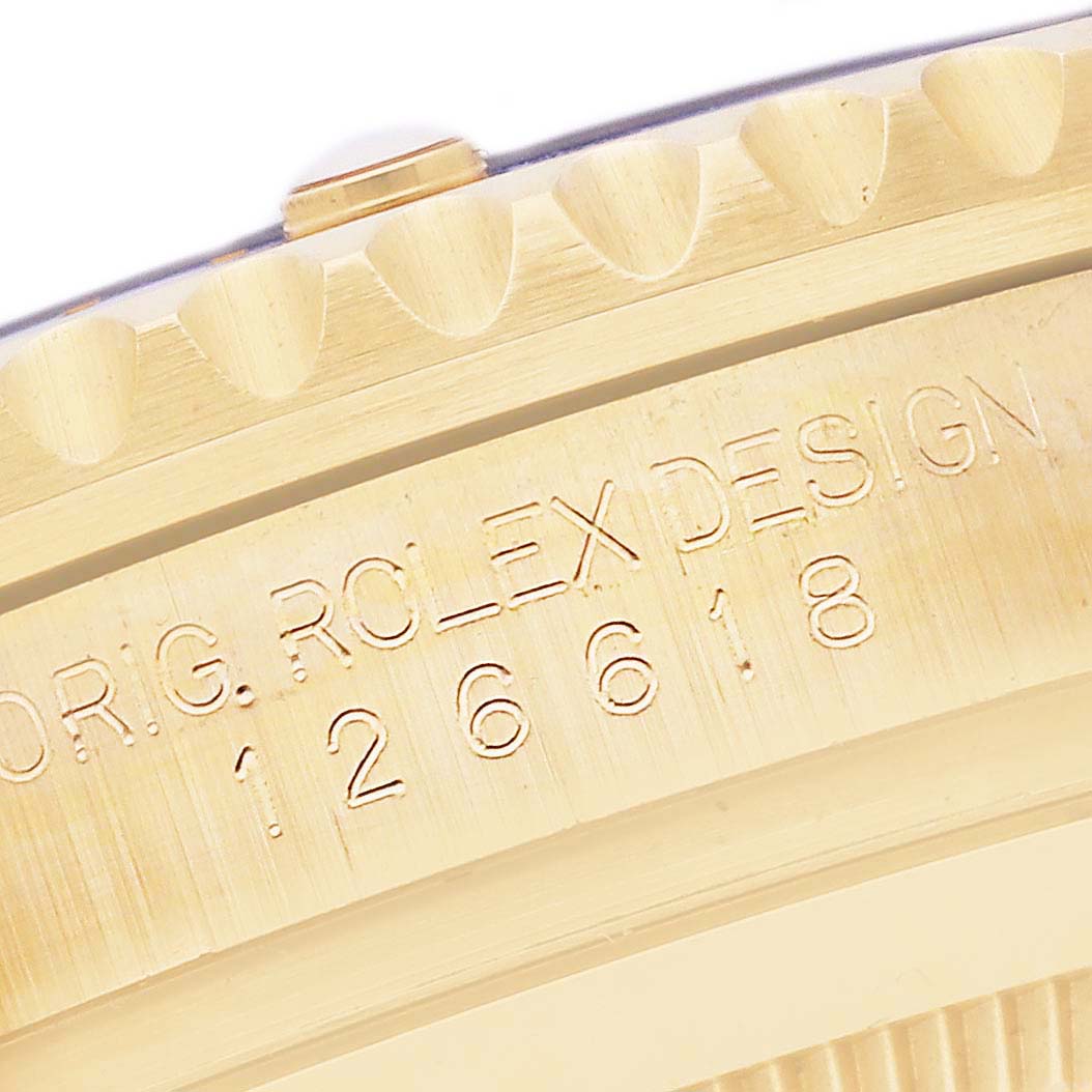 The image shows the edge of a Rolex Submariner 126618LB Men's Yellow Gold Blue Dial 126618LB Men's Yellow Gold Blue Dial, highlighting the engraved model design and part of the bezel.