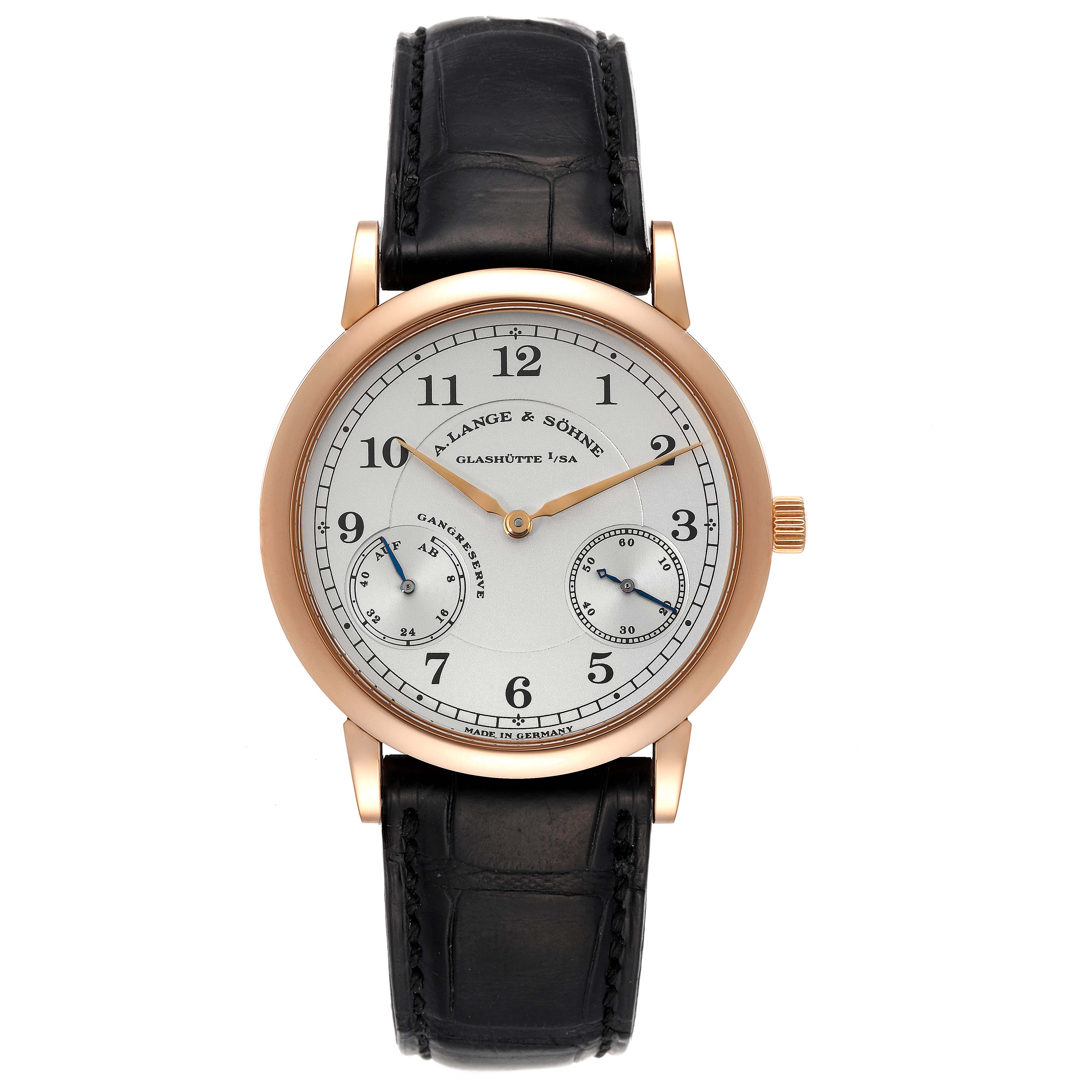 The image shows a front view of the 1815 model by A. Lange & Söhne, featuring a leather strap and a white dial with subdials.