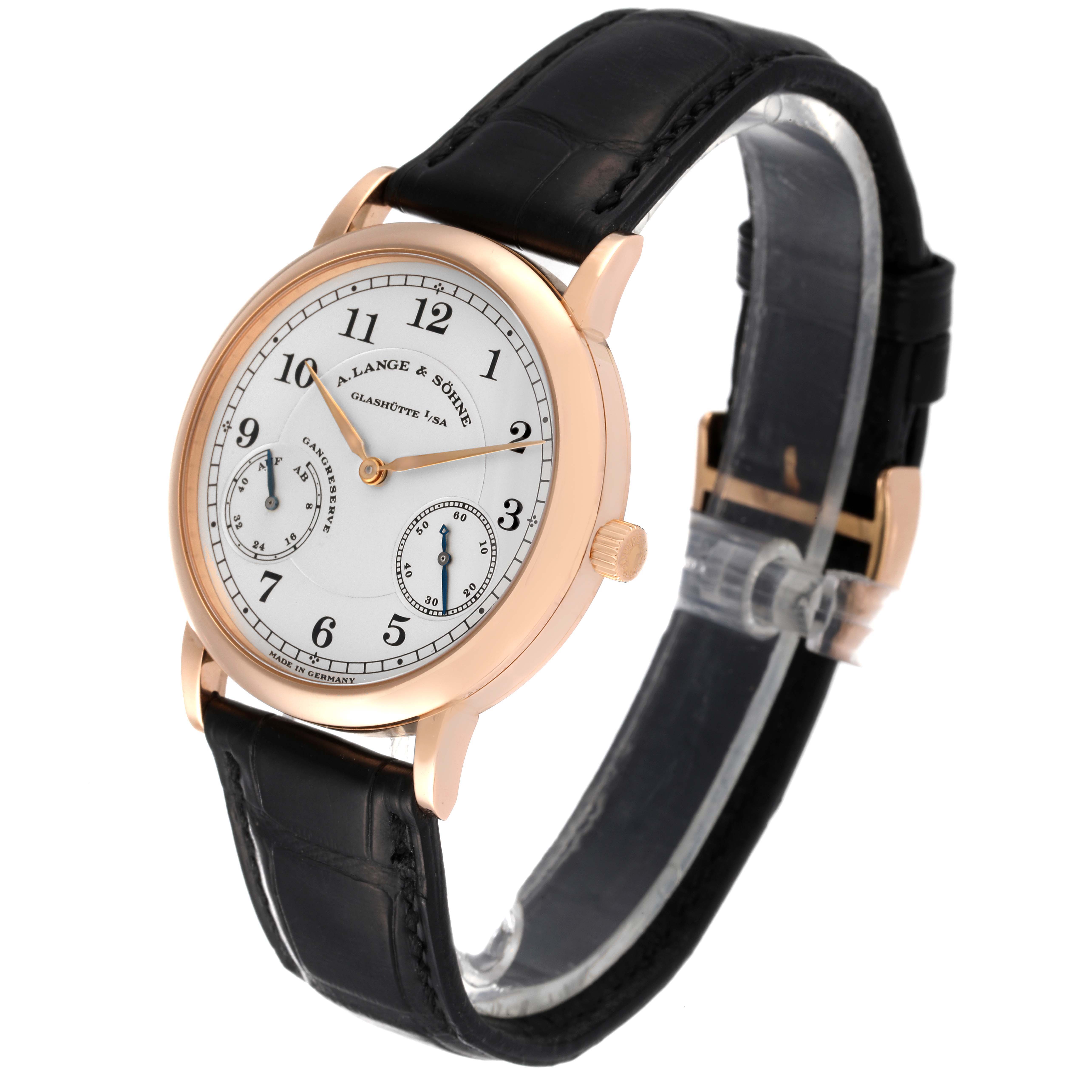 The image shows an angled view of an A. Lange & Sohne 1815 221.032 Men's Rose Gold Silver Dial watch, highlighting its face, crown, and leather strap.