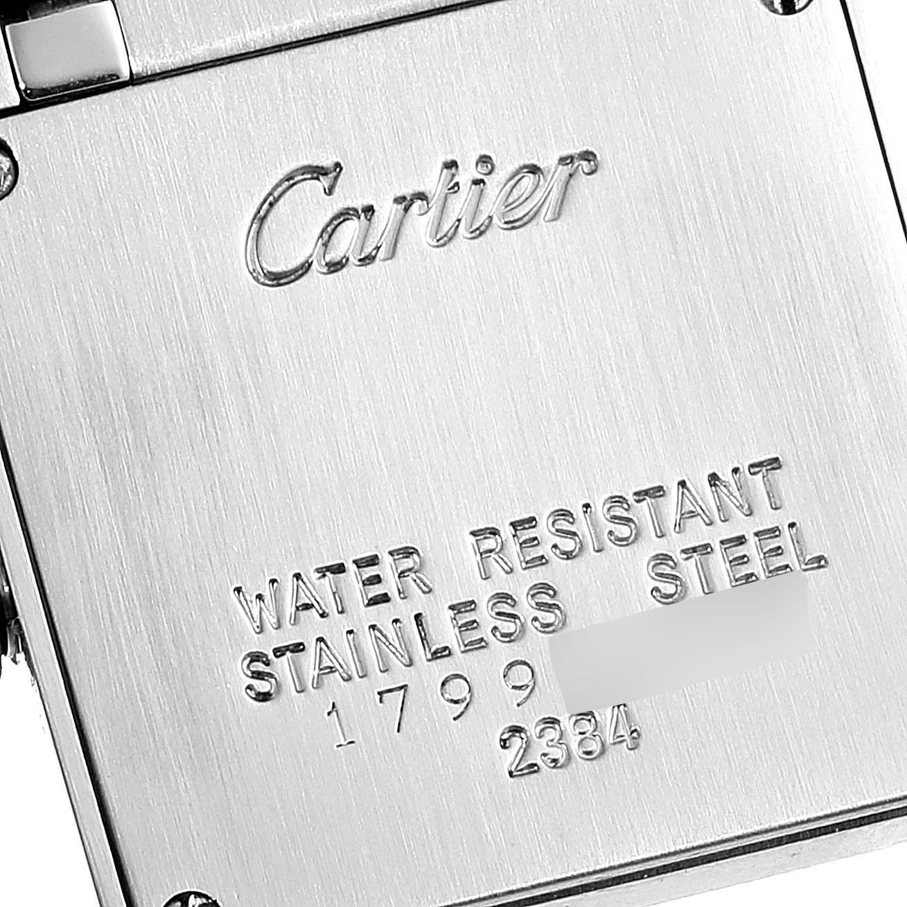 The image shows the back case of a Cartier Tank Française watch, highlighting its engravings and material.