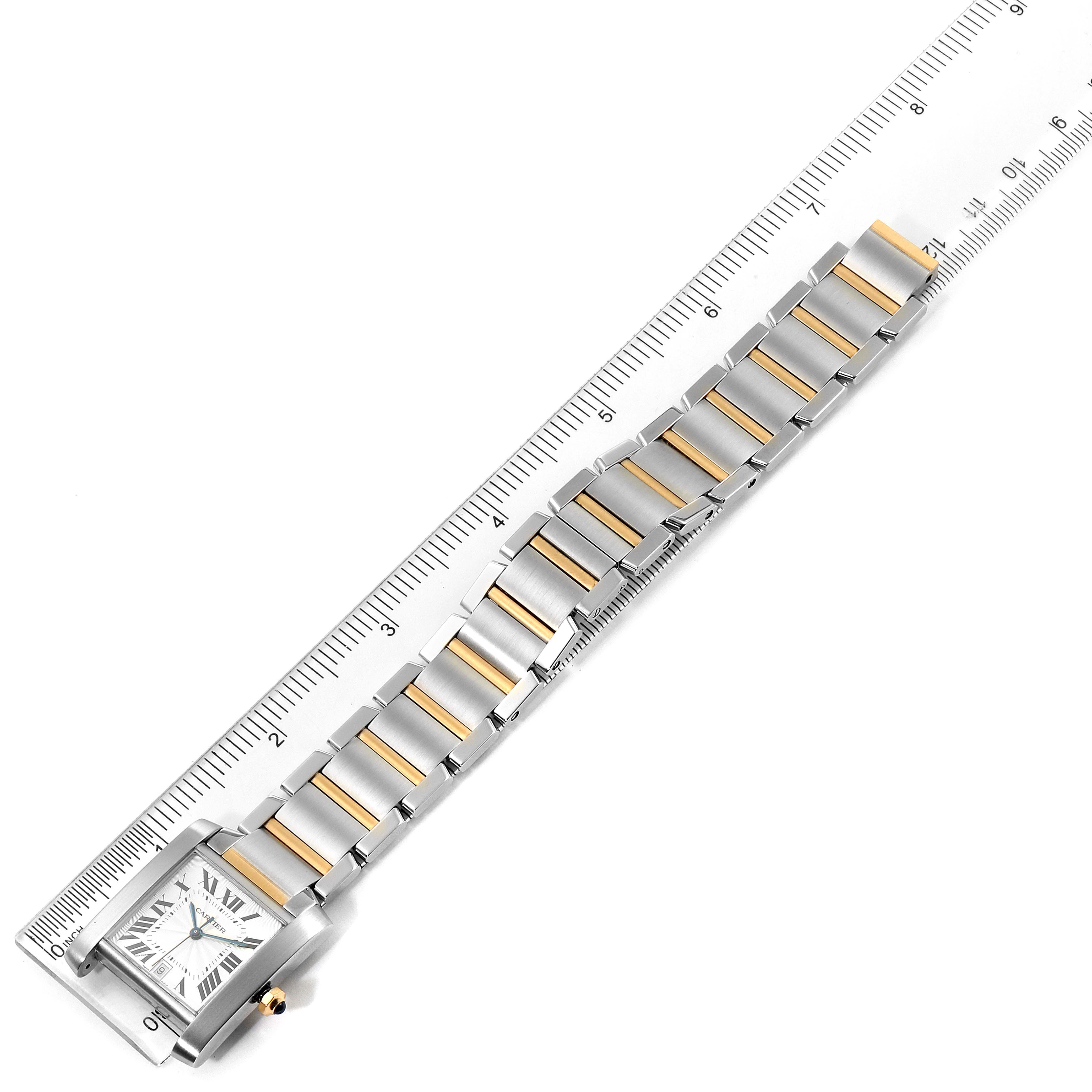 The image shows a Cartier Tank Française watch laid flat next to a ruler, highlighting its bracelet links and square dial.