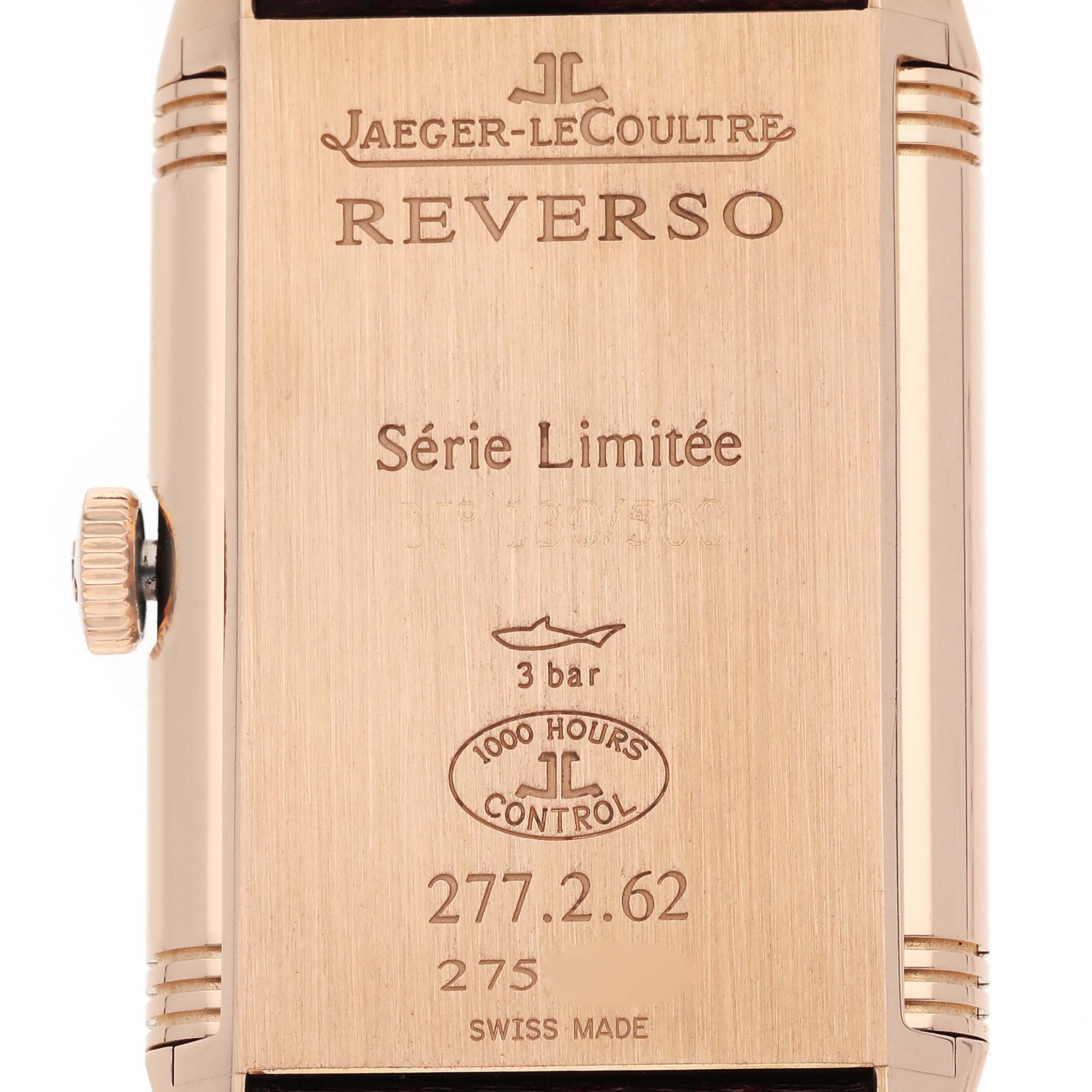 The image shows the back view of a Jaeger-LeCoultre Reverso watch, highlighting its engravings and crown.