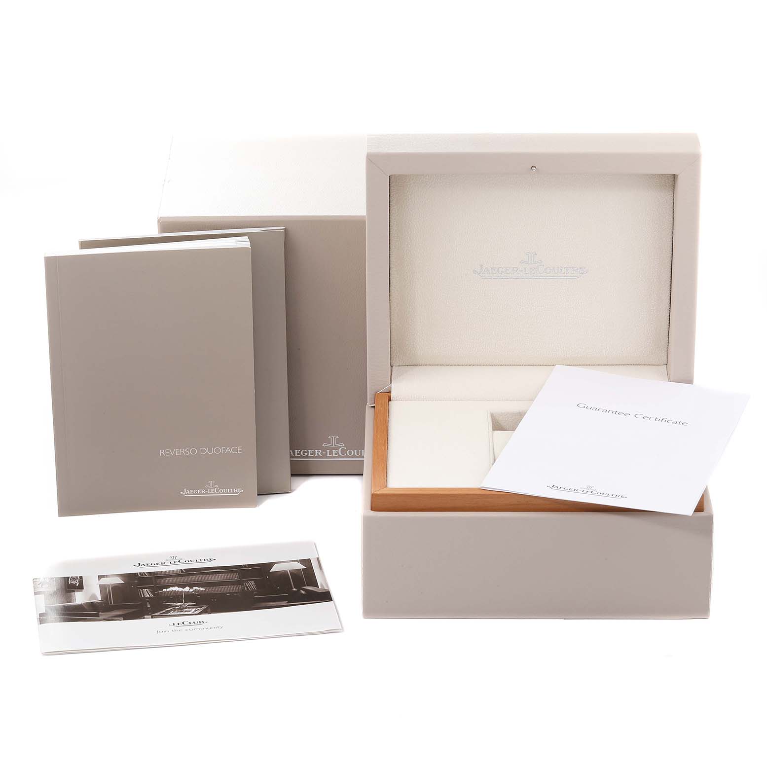 The image shows the packaging, manuals, guarantee certificate, and empty box of the Jaeger-LeCoultre Reverso model watch.