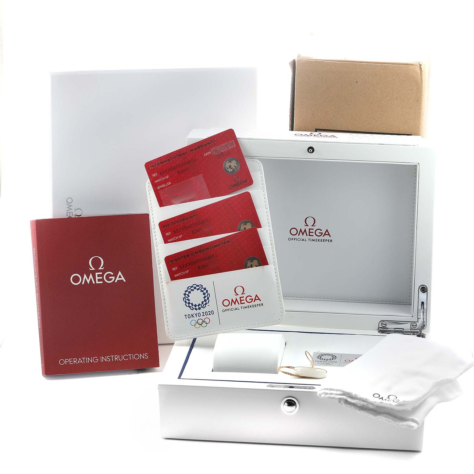 The image shows packaging and accessories for the Omega Seamaster 522.30.42.20.04.001 Men's Stainless Steel White Dial, including a box, instruction manual, and warranty cards.
