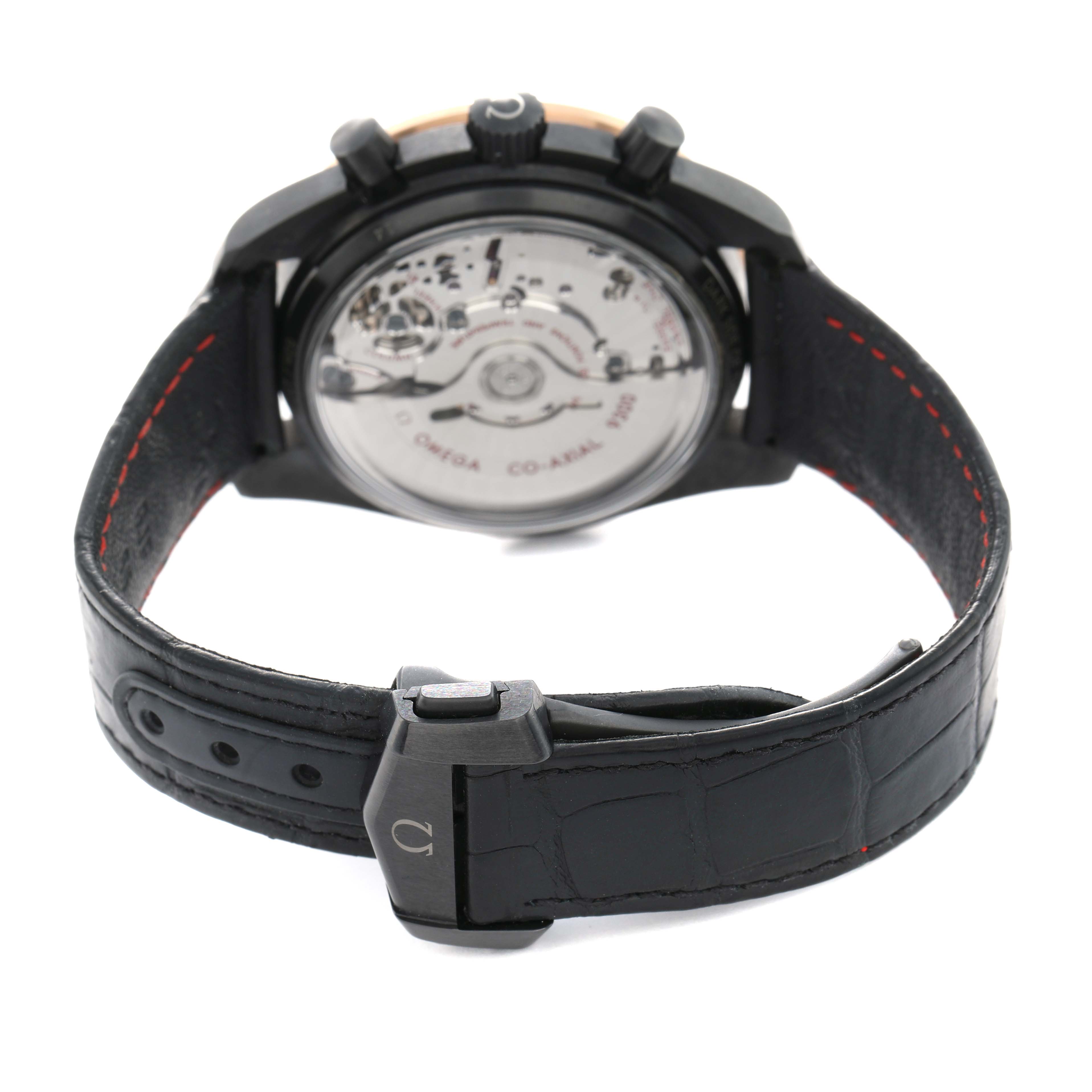 The Omega Speedmaster 311.63.44.51.06.001 Men's Ceramic Grey Dial watch is shown from the rear, highlighting its transparent case back and leather strap with deployment clasp.