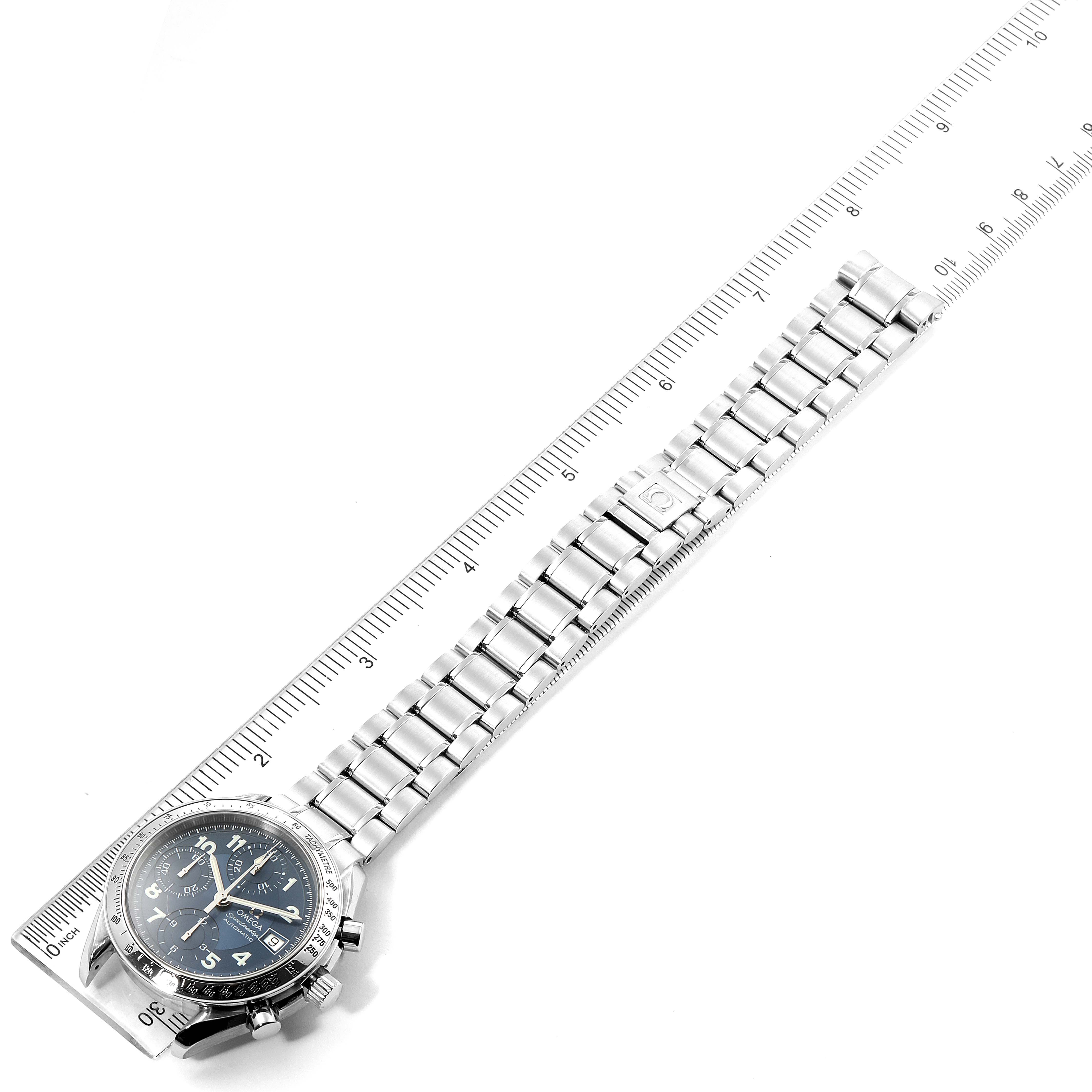 The image shows an Omega Speedmaster 3513.82.00 Men
s Stainless Steel Blue Dial 3513.82.00 Men
s Stainless Steel Blue Dial watch laid flat, alongside a ruler measuring its stainless steel bracelet and case.
