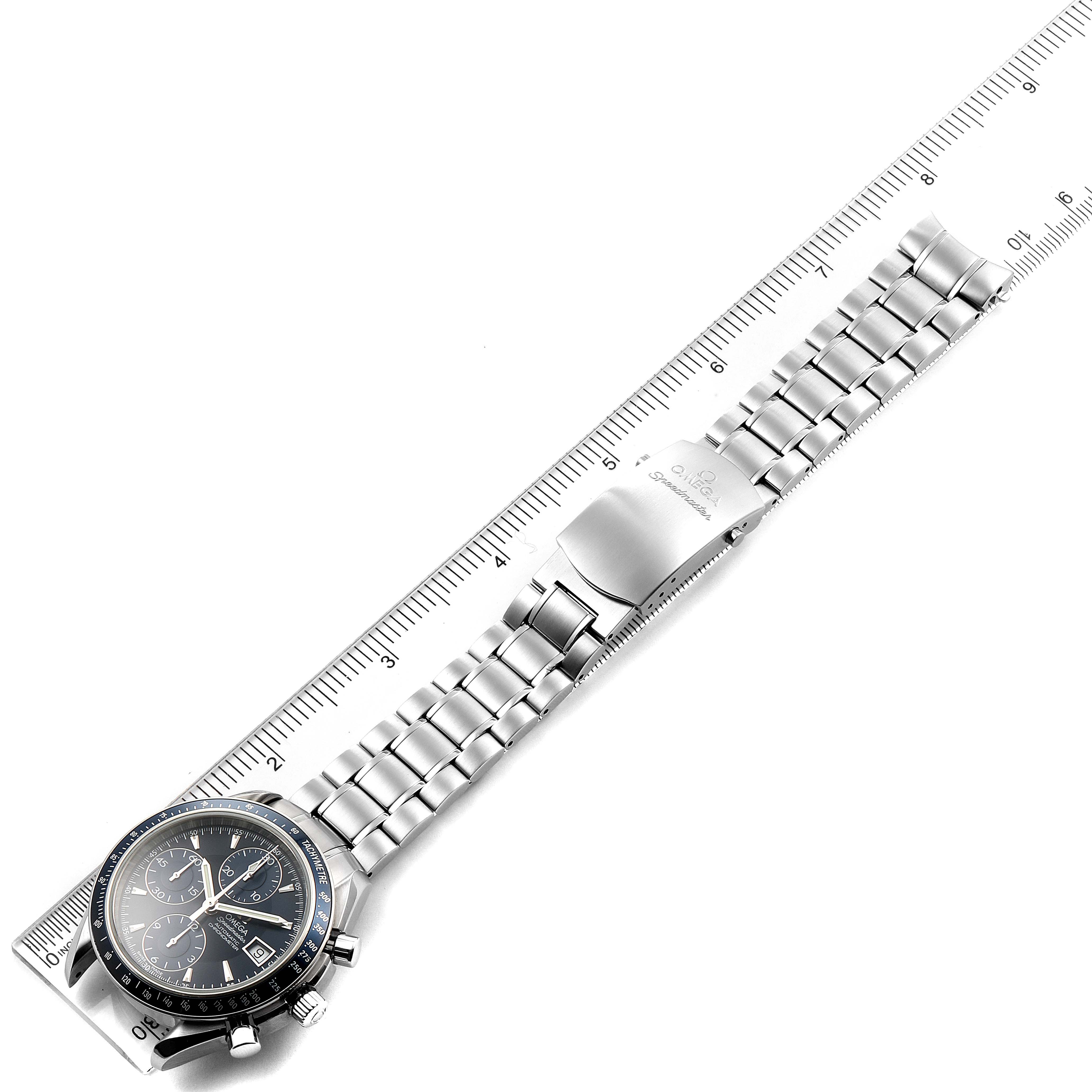 The Omega Speedmaster 3212.80.00 Men's Stainless Steel Blue Dial 3212.80.00 Men's Stainless Steel Blue Dial watch is shown in a flat lay, displaying its dial, bracelet, and clasp alongside a ruler for scale.