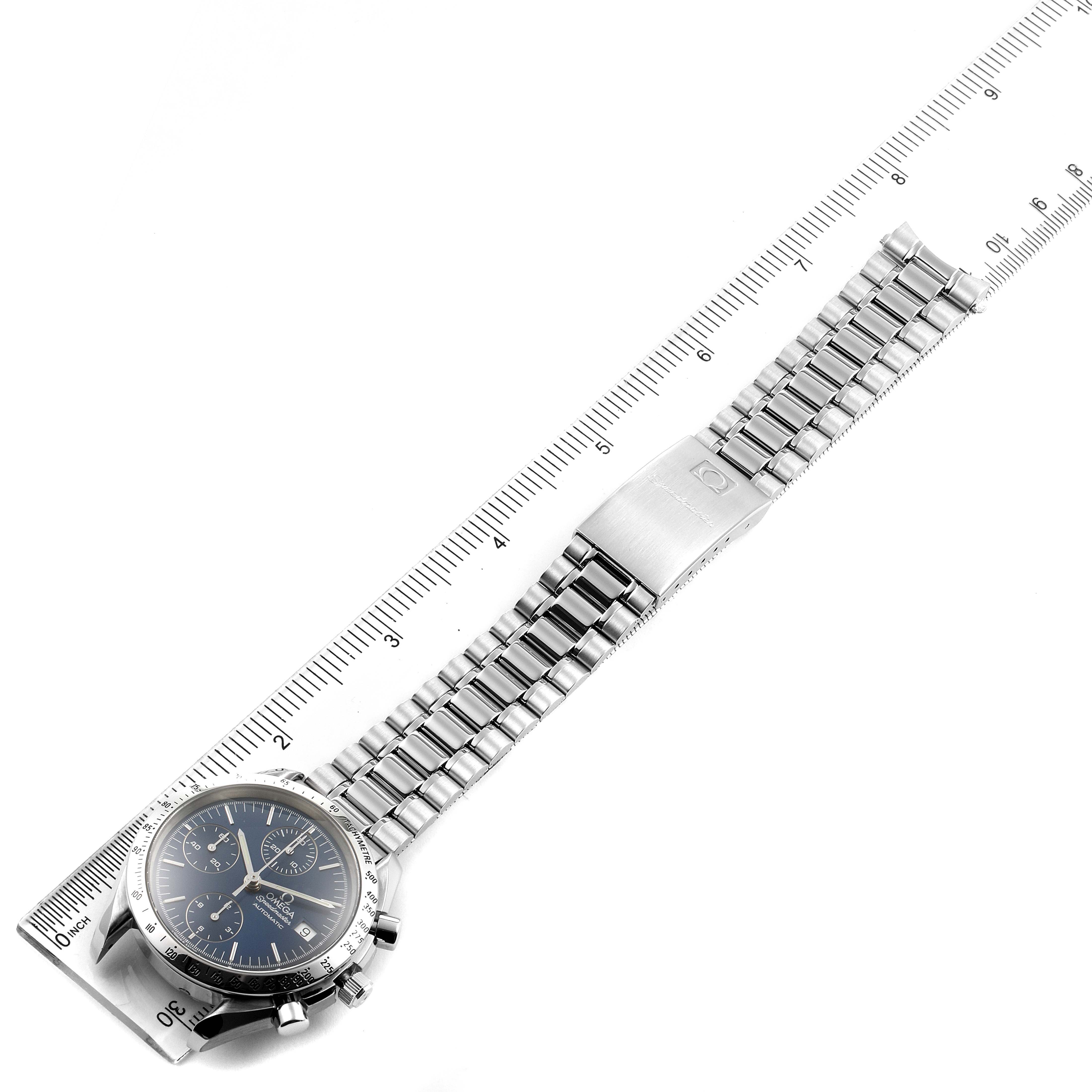 The Omega Speedmaster 3511.80.009 Men's Stainless Steel Blue Dial 3511.80.009 Men's Stainless Steel Blue Dial watch is shown from a top-down angle, displaying its face, bracelet, and clasp alongside a ruler for scale.
