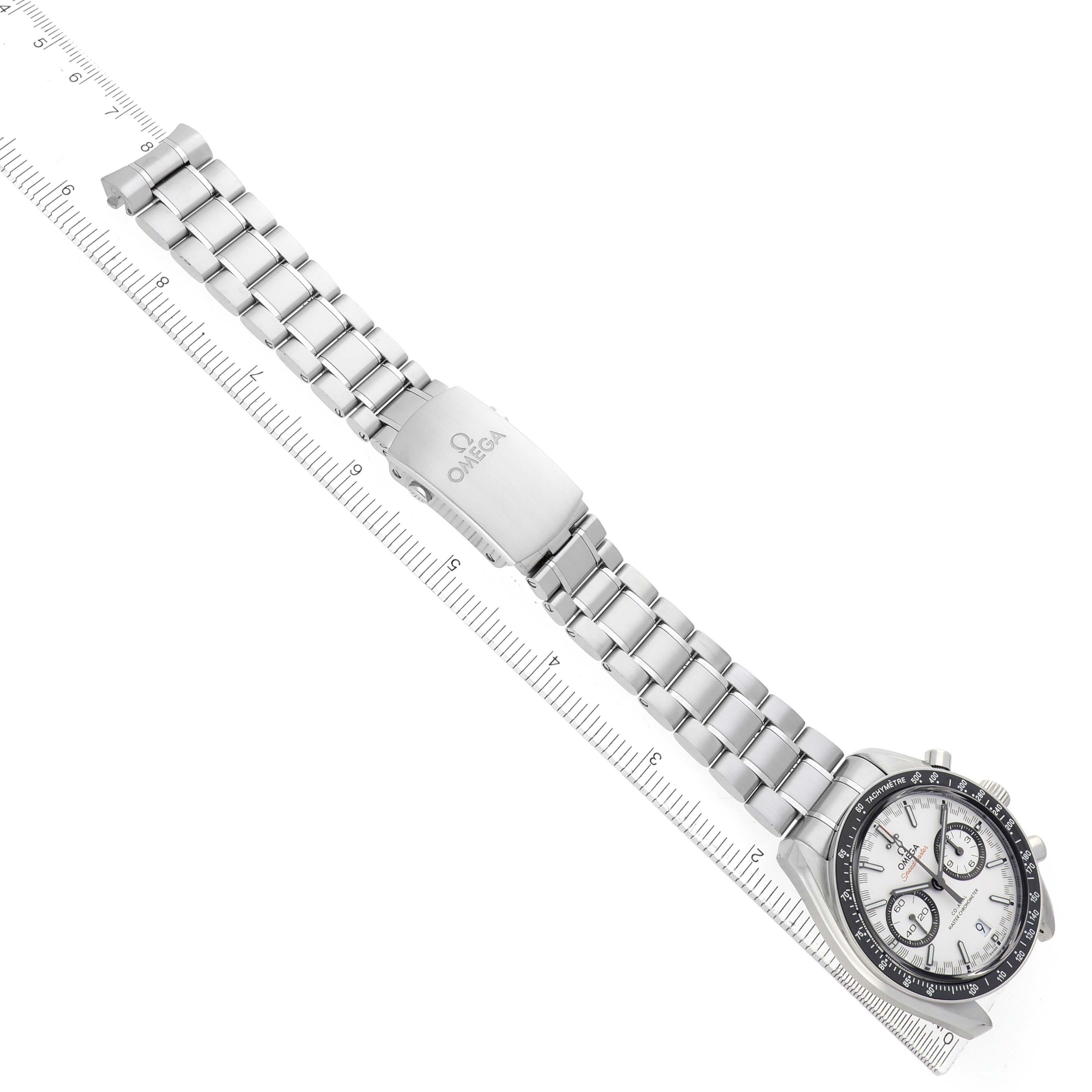 The Omega Speedmaster 329.30.44.51.04.001 Men's Stainless Steel Silver Dial watch is shown laid flat, displaying its face, bracelet, and clasp with a ruler for scale.