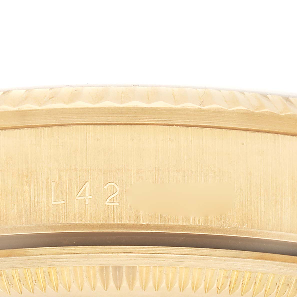 This image shows a close-up of the side of the Rolex Date 15238 Men's Yellow Gold White Dial watch case, highlighting engraved details.