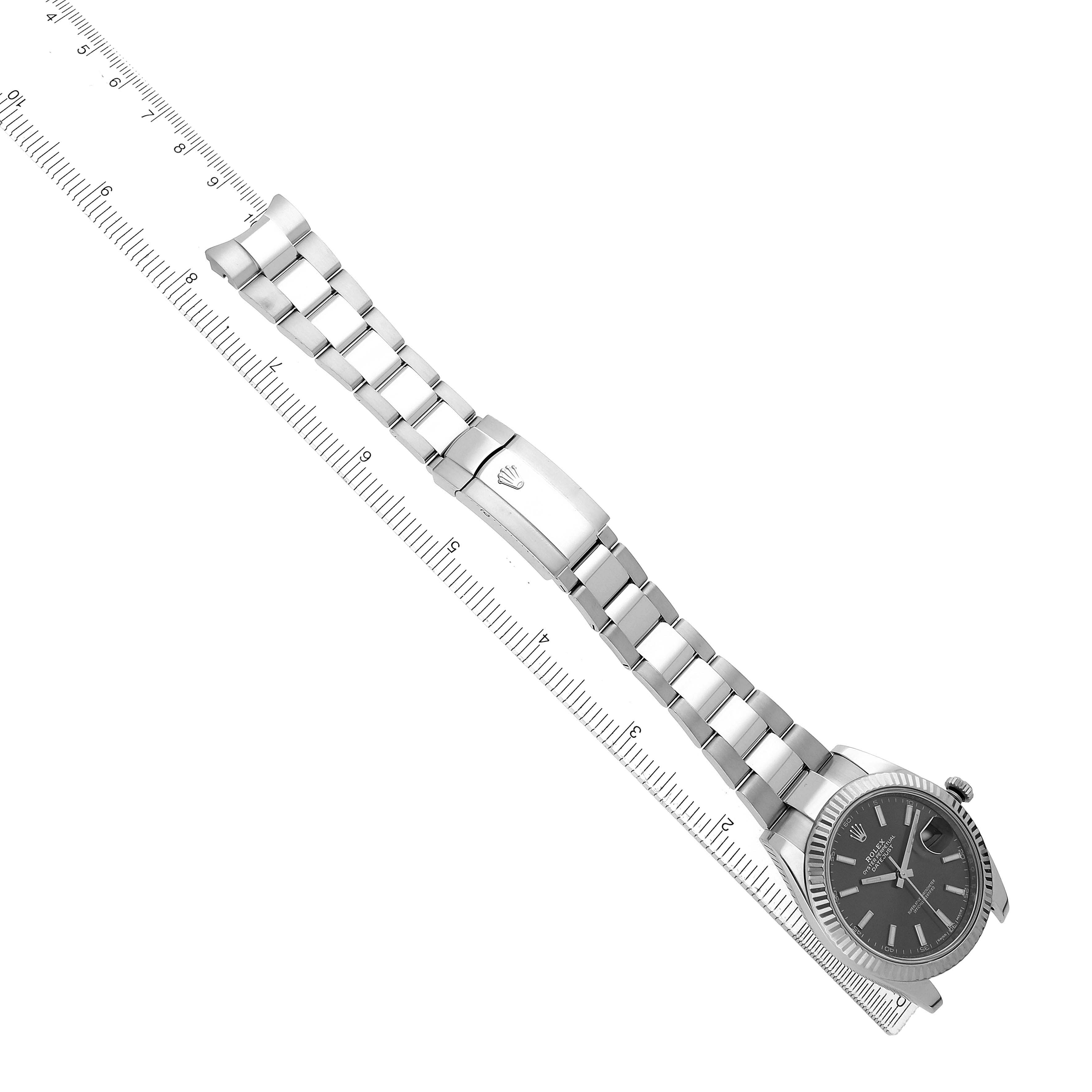 The Rolex Datejust 41 126334 Men's Stainless Steel Grey Dial is shown diagonally, displaying its face, bezel, and metal bracelet alongside a ruler for scale.