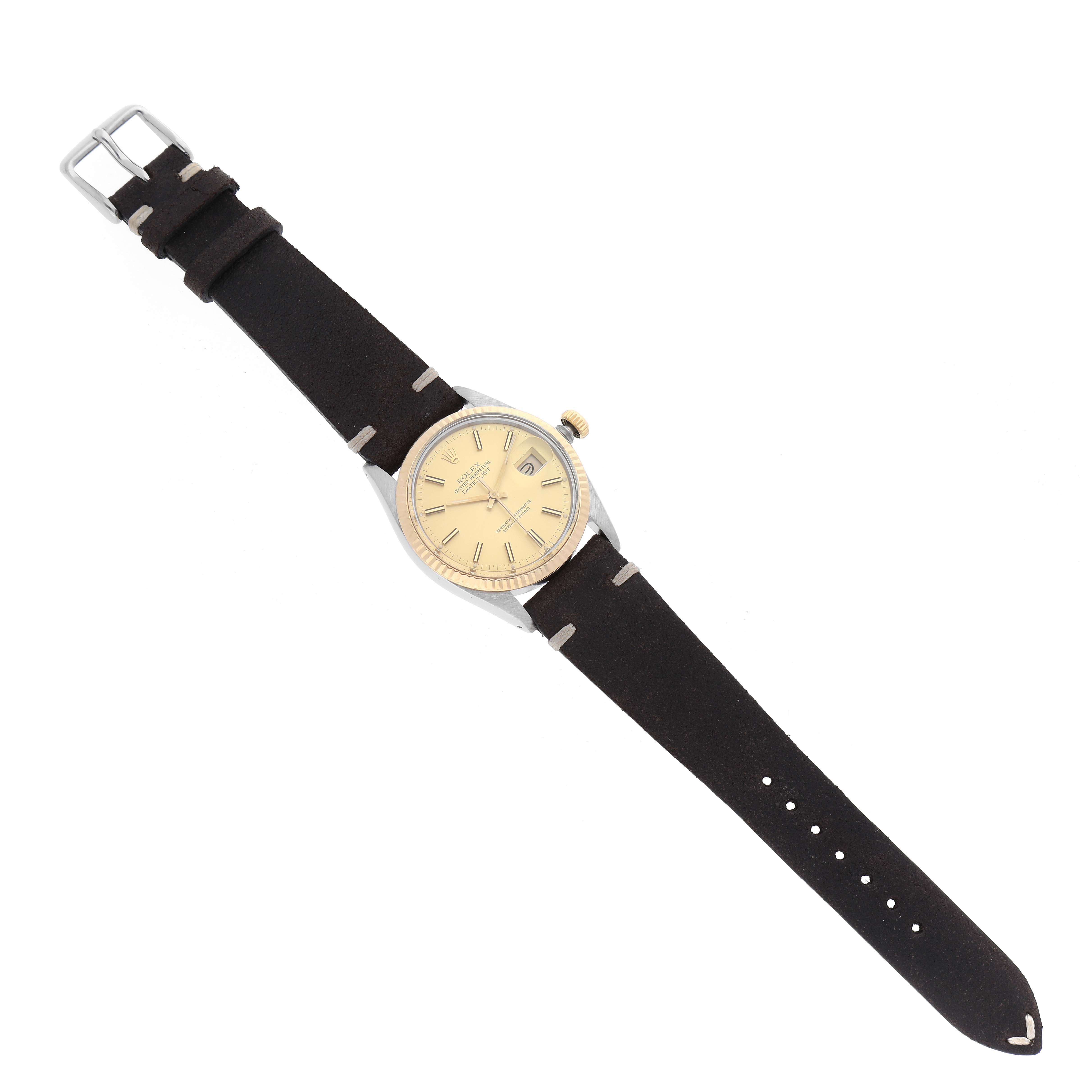 The image shows a top-down view of a Rolex Datejust 16013 Men's Steel and Gold (two tone) Champagne Dial 16013 Men's Steel and Gold (two tone) Champagne Dial watch with a beige dial and a black leather strap.