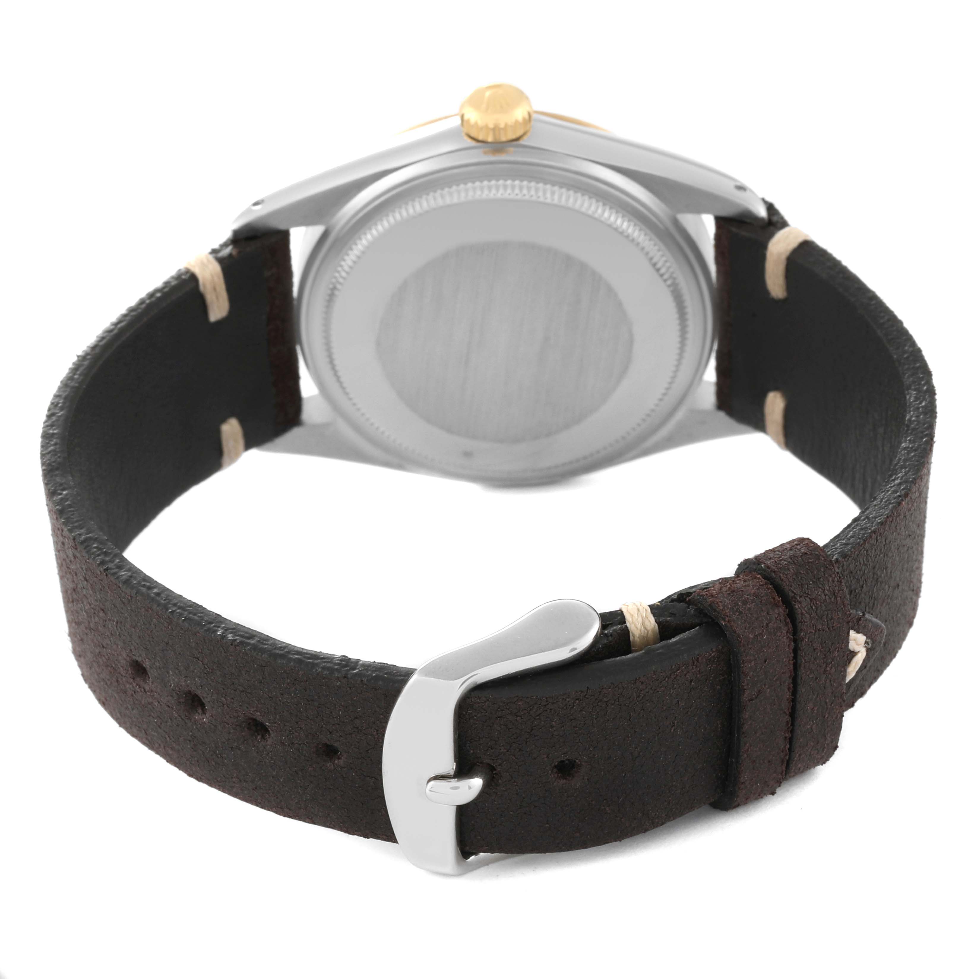 This image shows the rear view of a Rolex Datejust 16013 Men's Steel and Gold (two tone) Champagne Dial 16013 Men's Steel and Gold (two tone) Champagne Dial watch with a focus on the case back and a leather strap with a buckle.