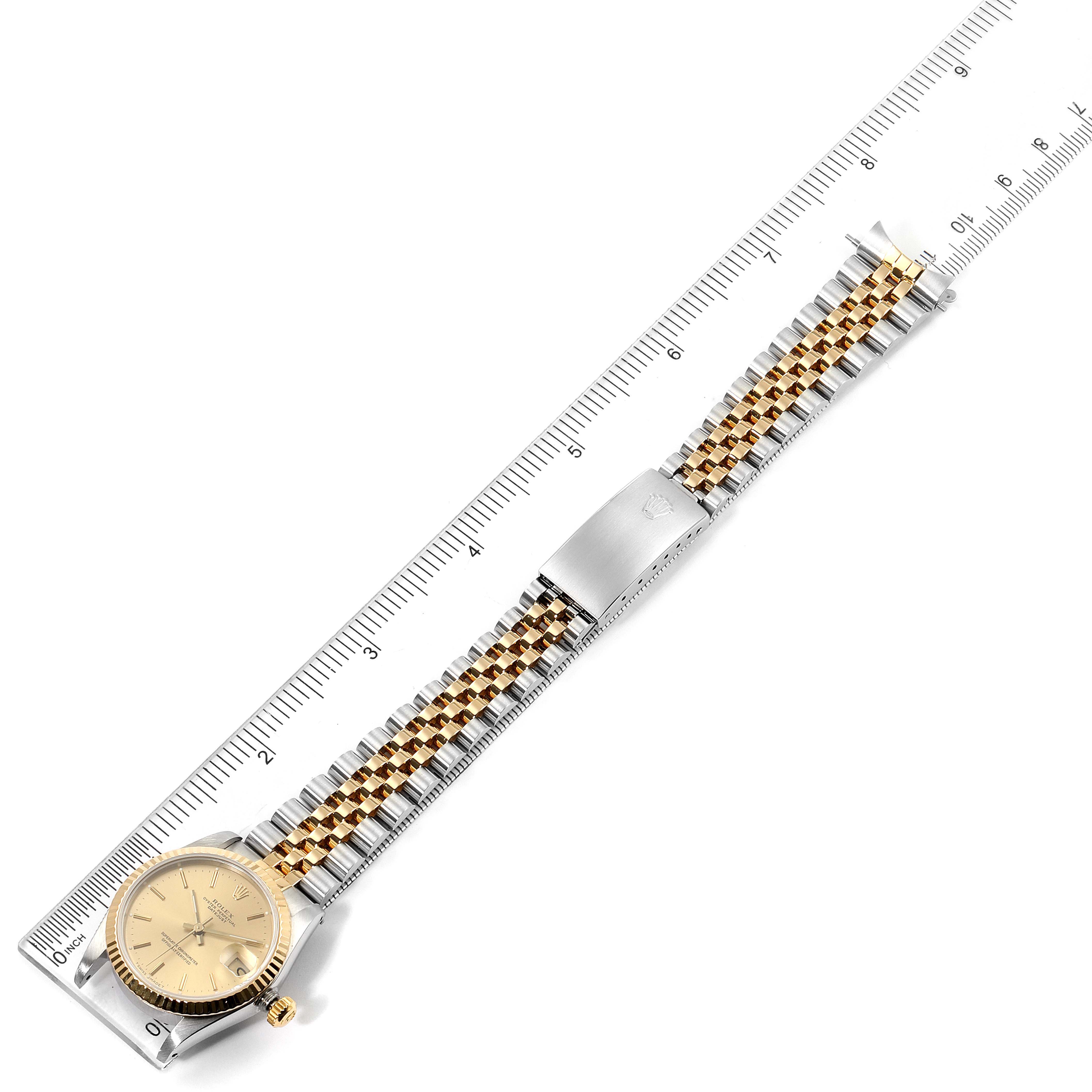 This image shows a Rolex Mid-Size 68273 Women's Steel and Gold (two tone) Champagne Dial 68273 Women's Steel and Gold (two tone) Champagne Dial model watch from an overhead angle, displaying the entire watch and a ruler for scale.