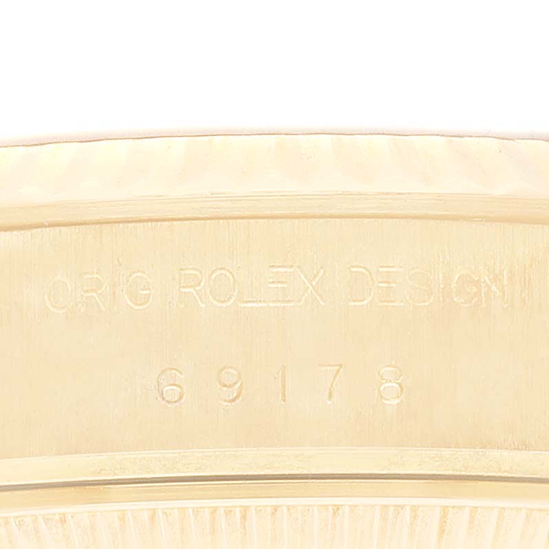 This image shows an engraving on the side of the Rolex President 69178G Women
s Yellow Gold Champagne Dial 69178G Women
s Yellow Gold Champagne Dial model, displaying the words "ORIG ROLEX DESIGN 69178."