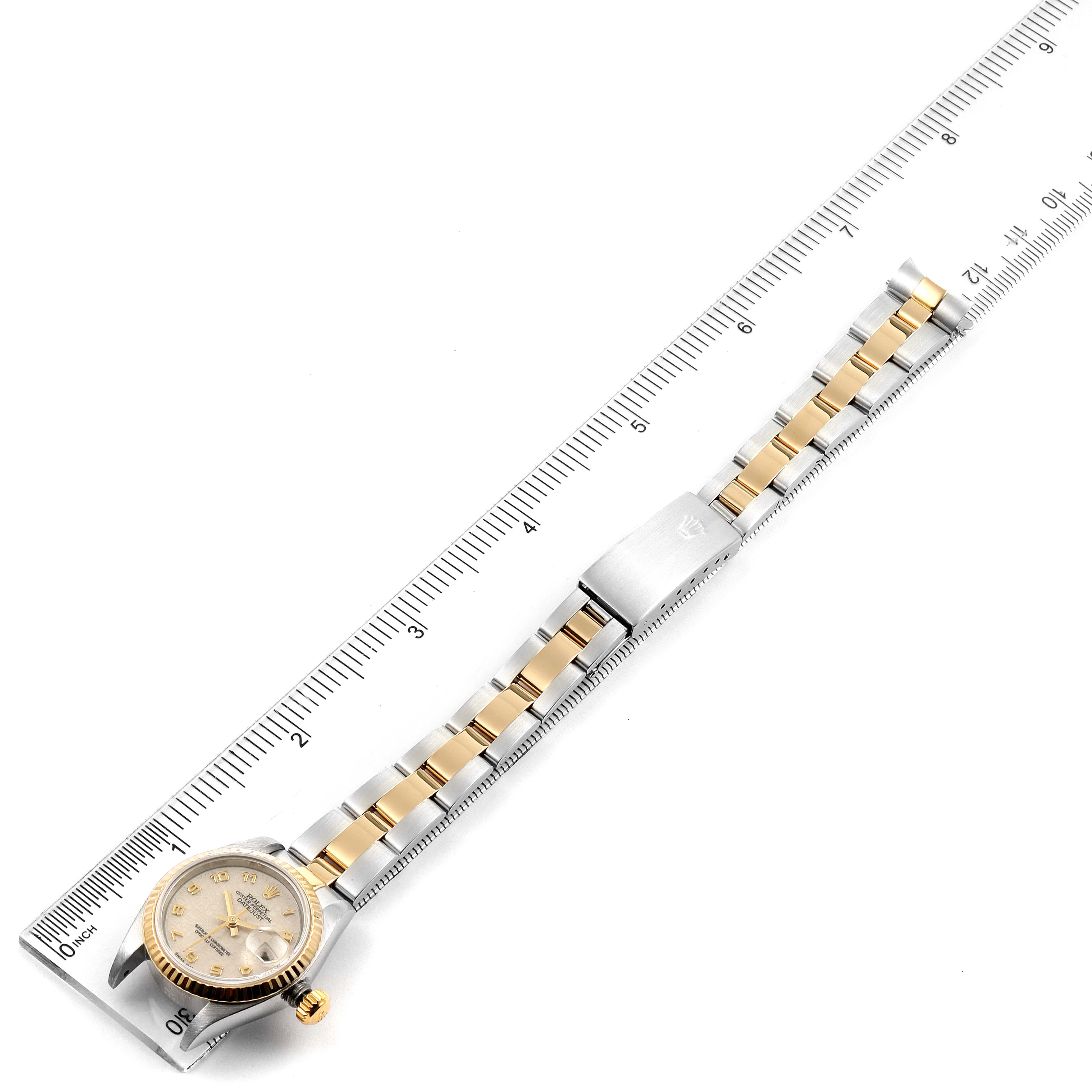 The image shows a Rolex Datejust 79173 Women
s Steel and Gold (two tone) Beige Dial 79173 Women
s Steel and Gold (two tone) Beige Dial watch laid flat with the face, bracelet, and clasp visible, alongside a measuring ruler.