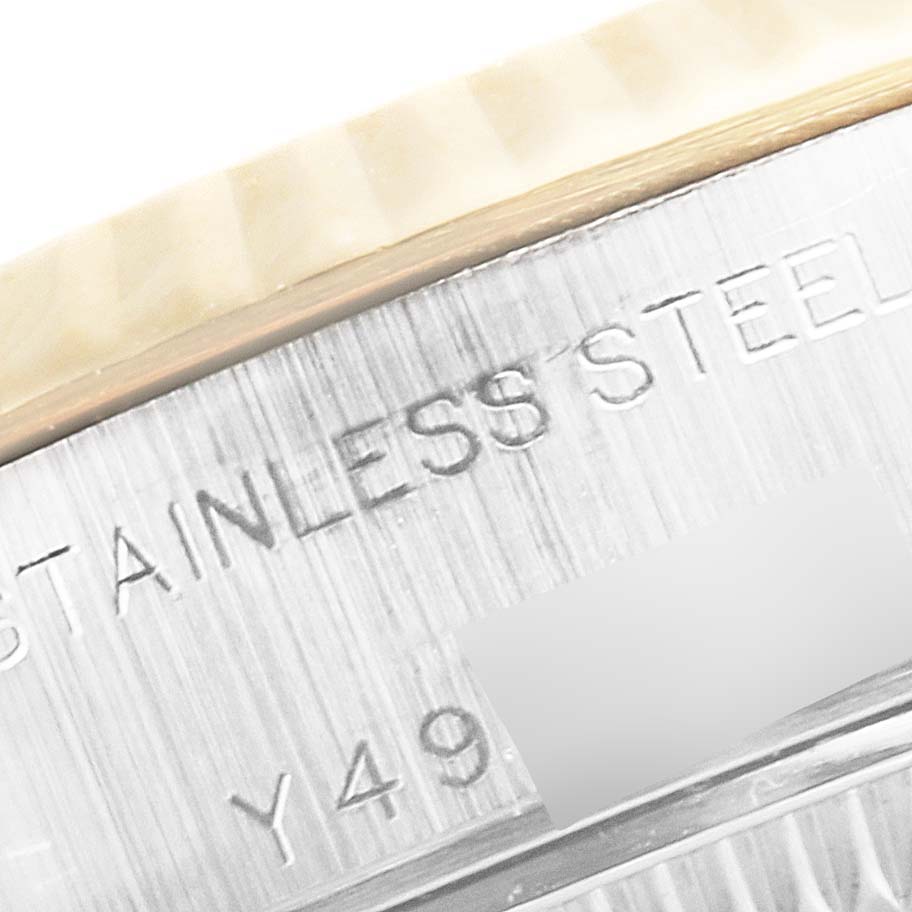 This close-up shows the side of the case of a Rolex Datejust 79173 Women
s Steel and Gold (two tone) Beige Dial 79173 Women
s Steel and Gold (two tone) Beige Dial watch, featuring engraving on its stainless steel surface.