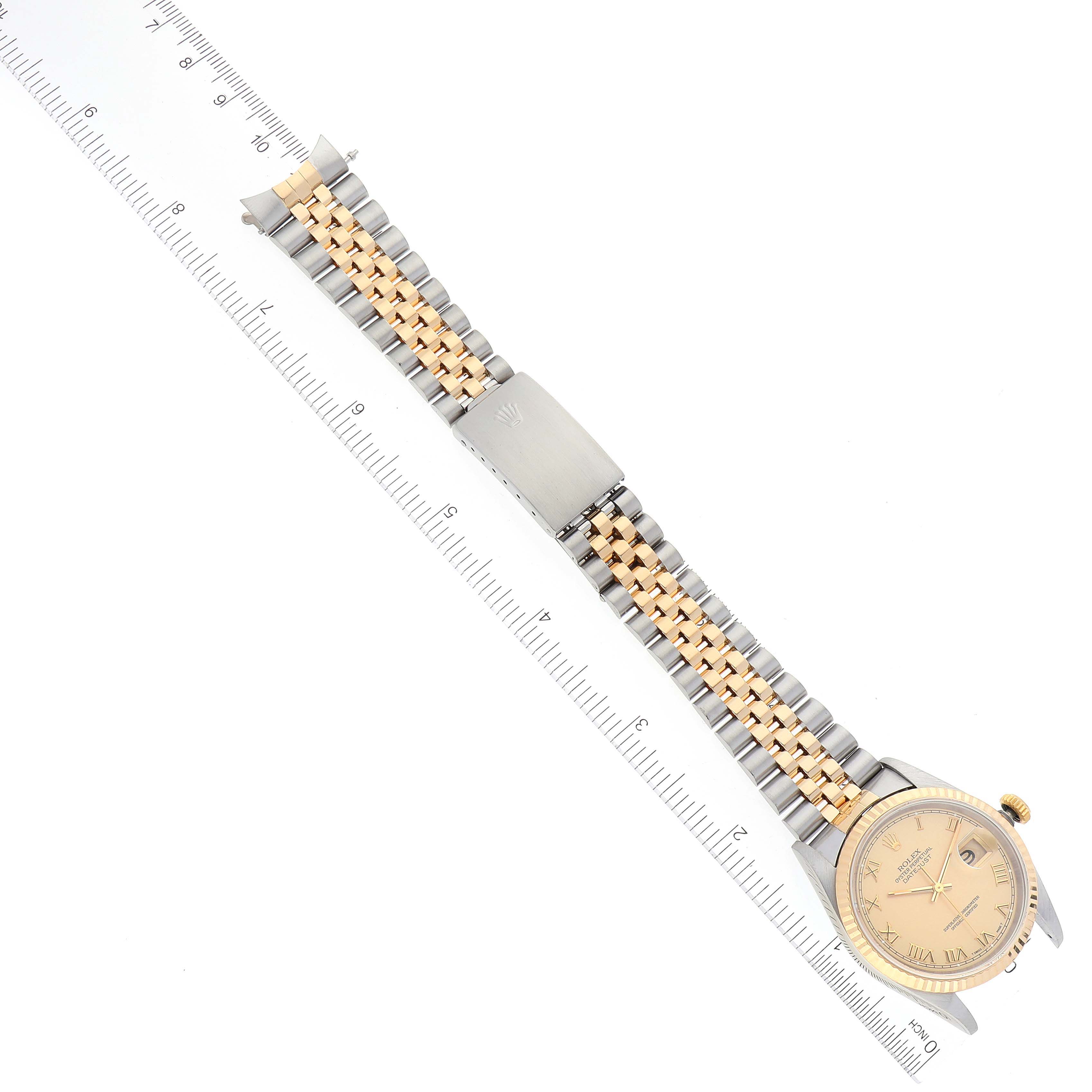 The Rolex Datejust 16233 Men's Steel and Gold (two tone) Champagne Dial 16233 Men's Steel and Gold (two tone) Champagne Dial watch is shown from a top-down angle, displaying the face, the two-tone bracelet, and clasp, measured alongside a ruler.