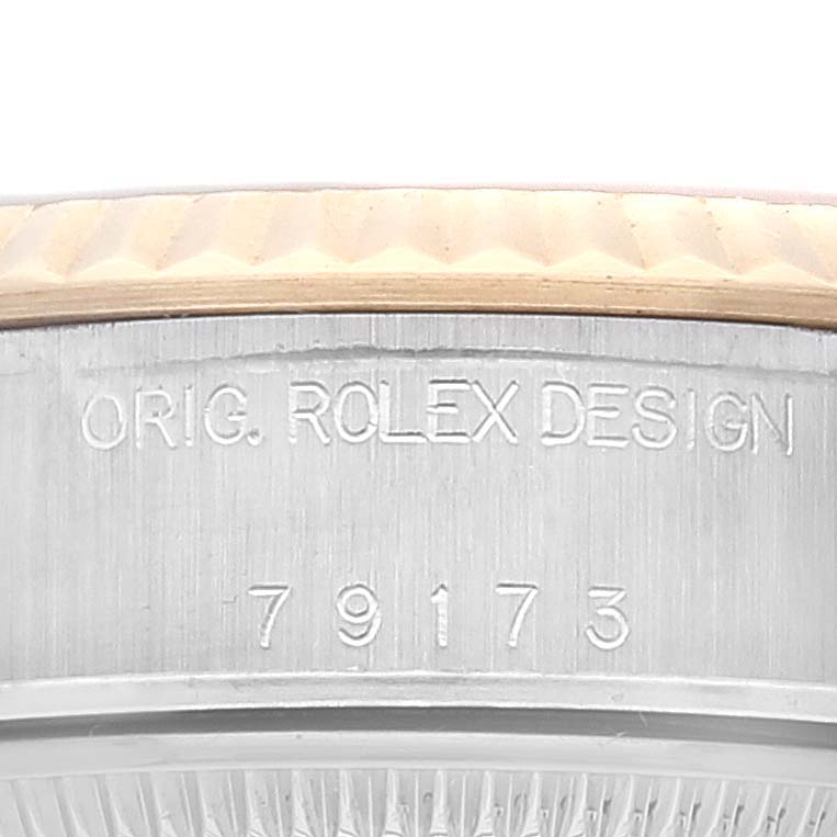 This image shows a close-up of the case side of a Rolex Datejust 79173 Women's Steel and Gold (two tone) Champagne Dial 79173 Women's Steel and Gold (two tone) Champagne Dial watch, displaying the model number "79173" and "ORIG. ROLEX DESIGN" engraving.