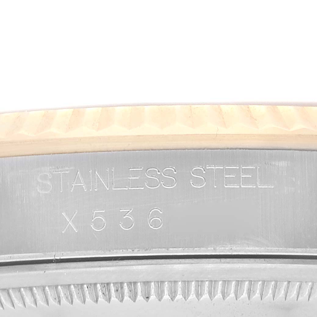 This close-up image shows the engraved "STAINLESS STEEL" marking on the case of a Rolex Datejust 16233 Men's Steel and Gold (two tone) Champagne Dial 16233 Men's Steel and Gold (two tone) Champagne Dial watch.