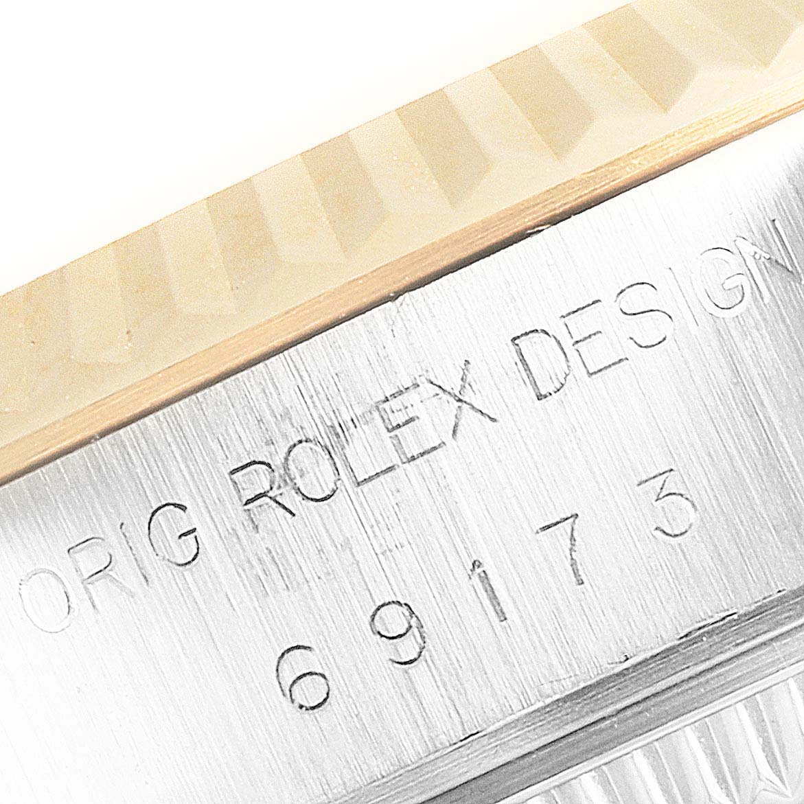 This close-up shows the engraved markings on the case side and the edge of the bezel of a Rolex Datejust 69173 Women's Steel and Gold (two tone) Champagne Dial 69173 Women's Steel and Gold (two tone) Champagne Dial watch.