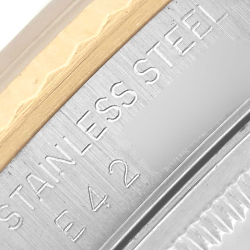 The image shows a close-up of the Rolex Datejust 16233 Men's Steel and Gold (two tone) Grey Dial 16233 Men's Steel and Gold (two tone) Grey Dial case, highlighting the stainless steel and gold parts with engraved text.