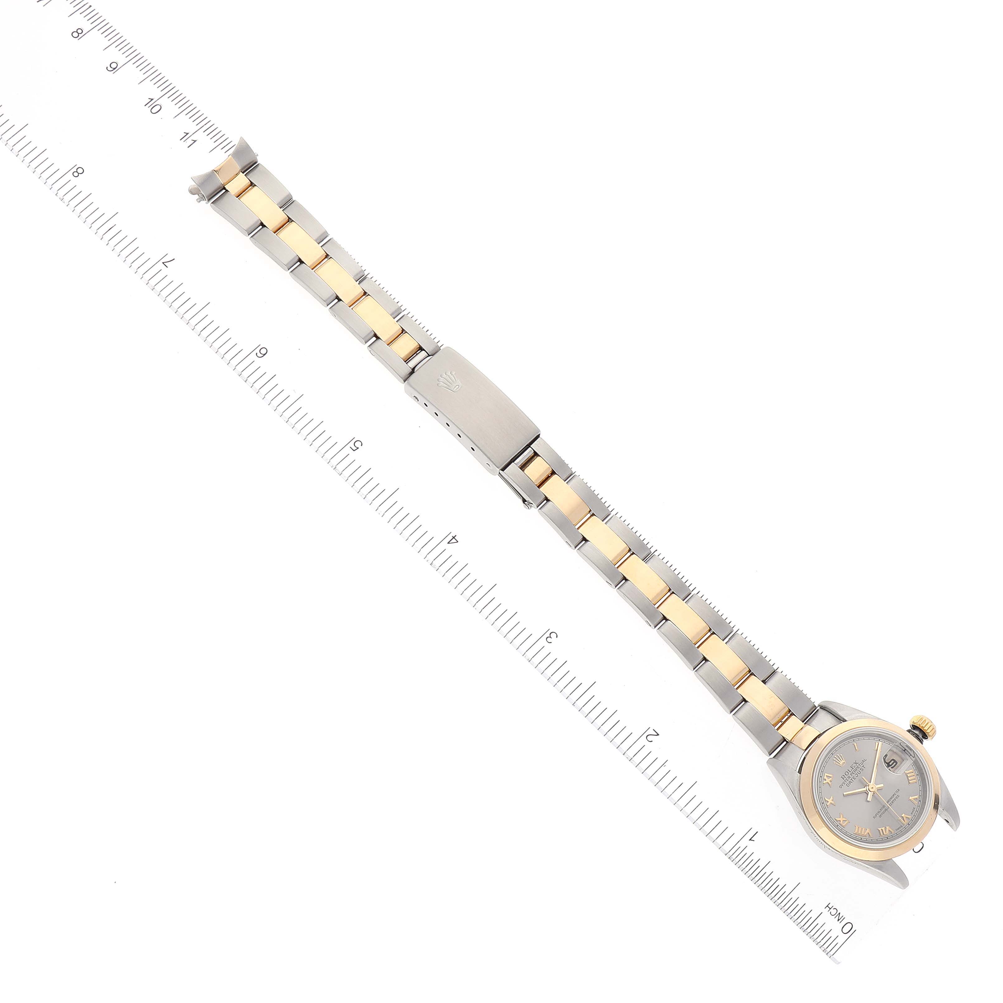 The image shows a top-down view of a Rolex Datejust 79163 Women's Steel and Gold (two tone) Grey Dial 79163 Women's Steel and Gold (two tone) Grey Dial watch with its bracelet fully extended alongside a measuring tool.