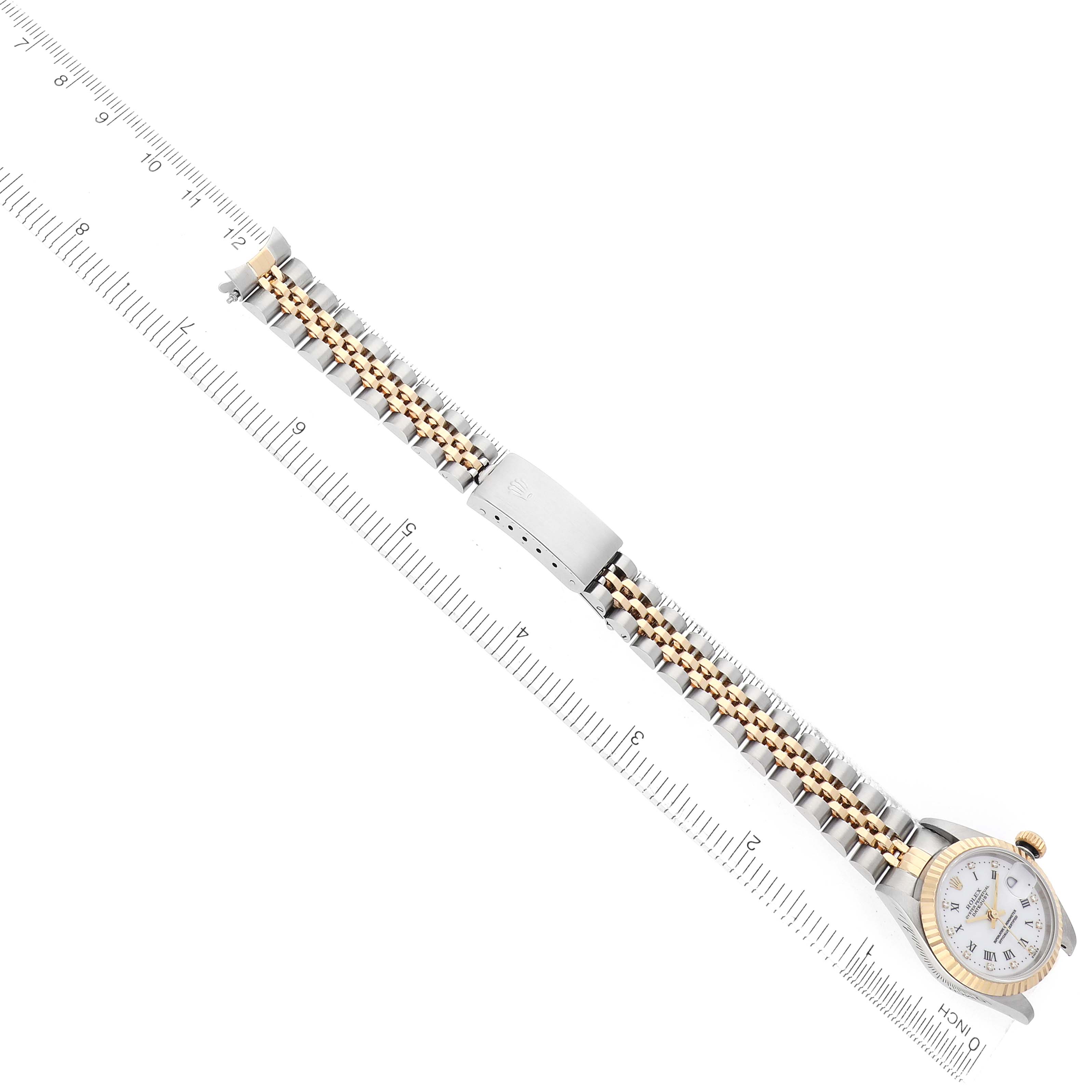 The Rolex Datejust 79173 Women's Steel and Gold (two tone) White Dial watch is shown flat with a focus on its bracelet, clasp, and part of the dial, aligned with a ruler.
