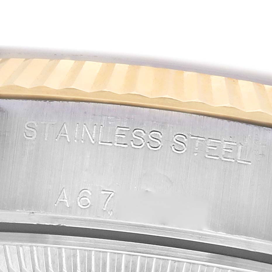 The image shows a close-up of the bezel and edge of the case back of a Rolex Datejust 79173 Women's Steel and Gold (two tone) White Dial, highlighting the stainless steel and gold details.