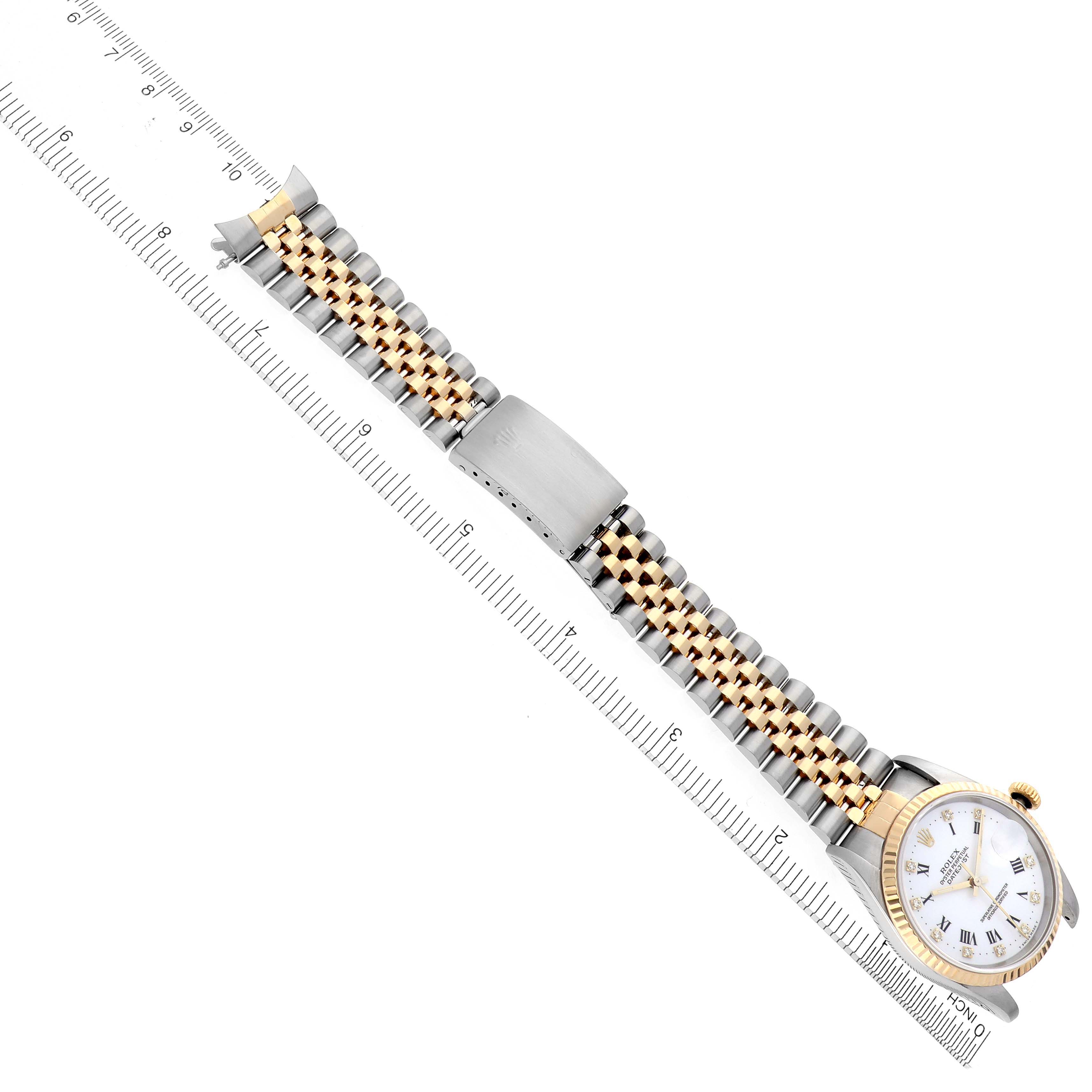 The Rolex Datejust 16233 Men's Steel and Gold (two tone) White Dial 16233 Men's Steel and Gold (two tone) White Dial watch is shown from a top angle, displaying the face, bracelet, and clasp alongside a ruler.