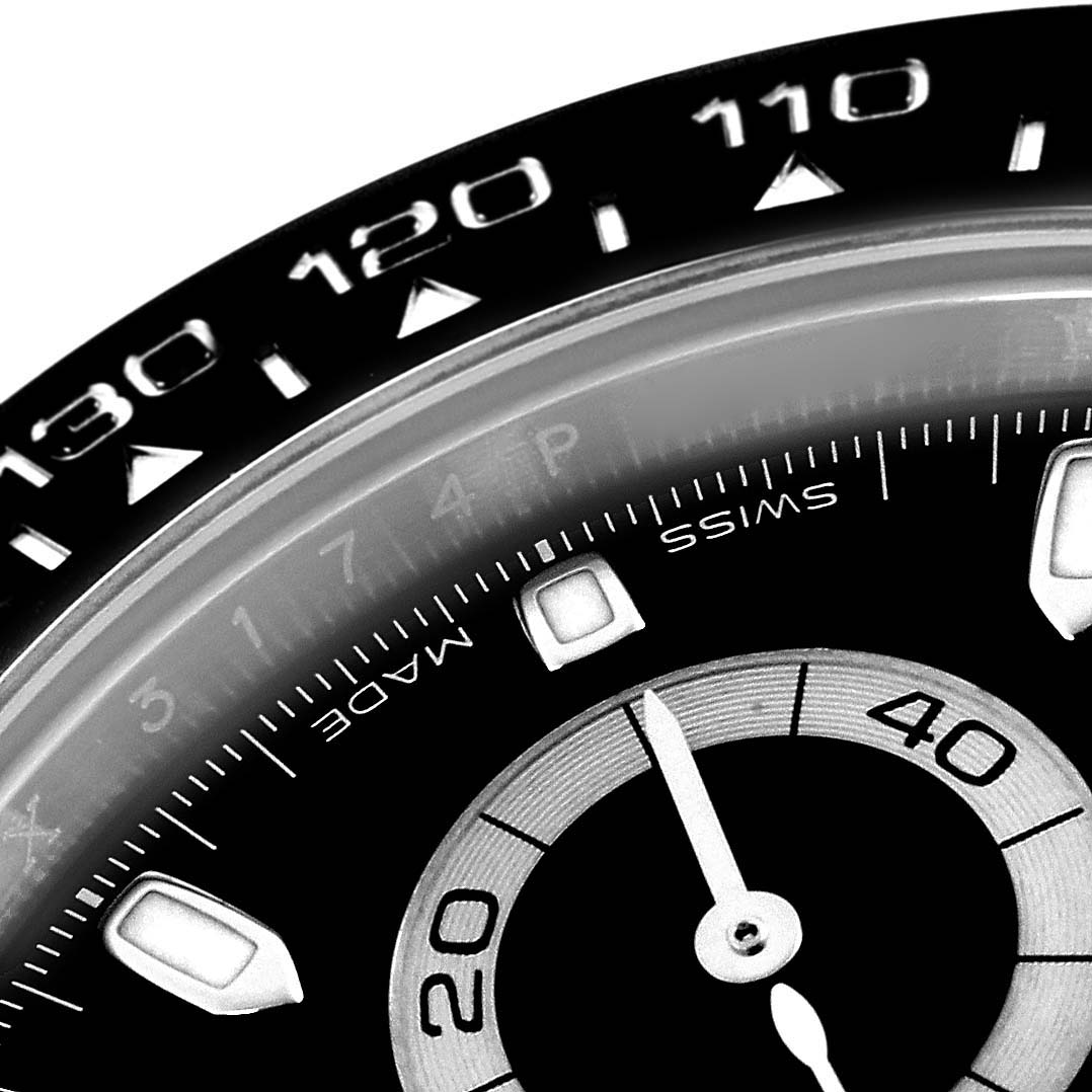 The image shows a close-up of the bezel and part of the dial of a Rolex Daytona 116500LN Men
s Stainless Steel Black Dial 116500LN Men
s Stainless Steel Black Dial watch.