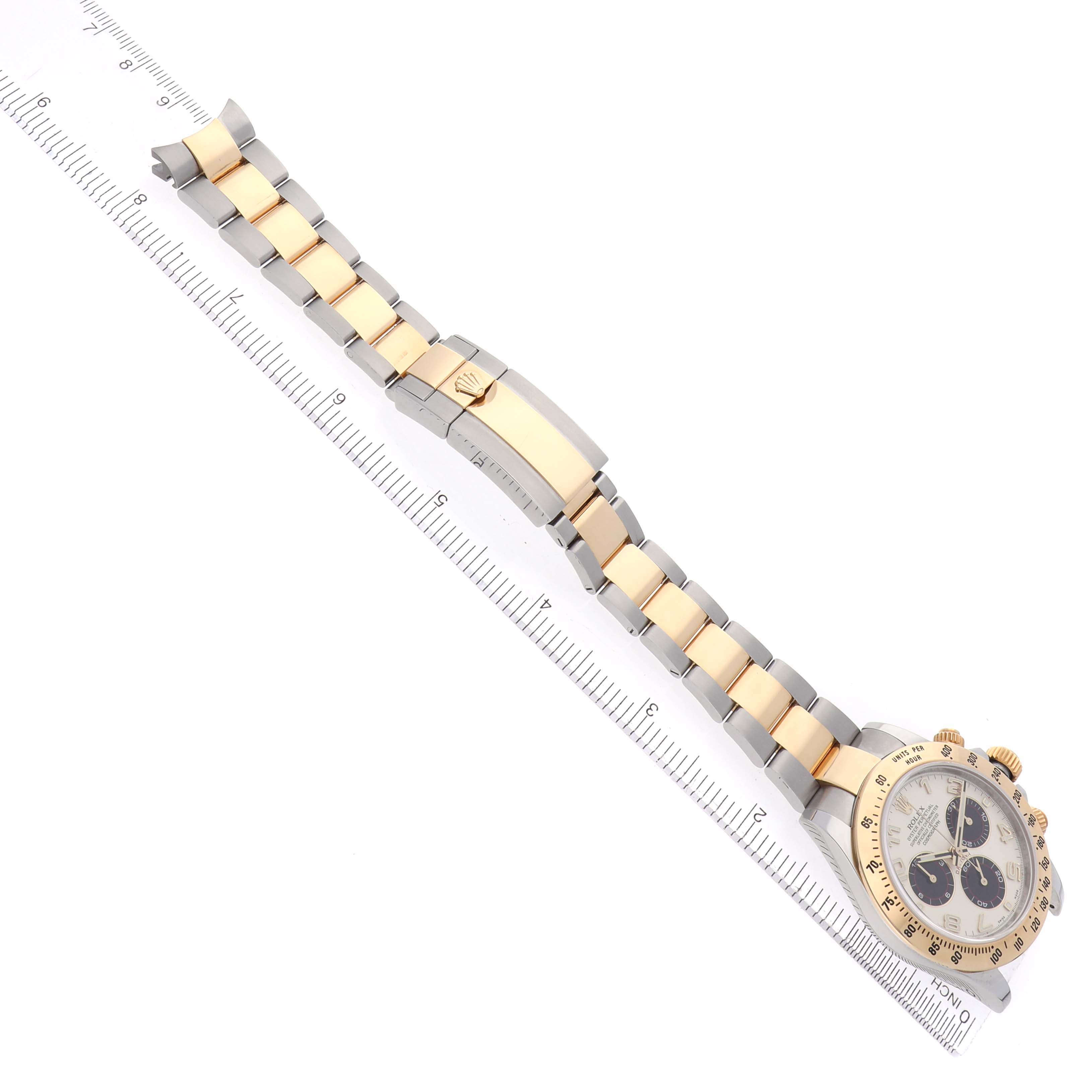 The Rolex Daytona 116523 Men's Steel and Gold (two tone) Silver Dial watch is shown from a top view, highlighting the face, bezel, and bracelet with a ruler for scale.