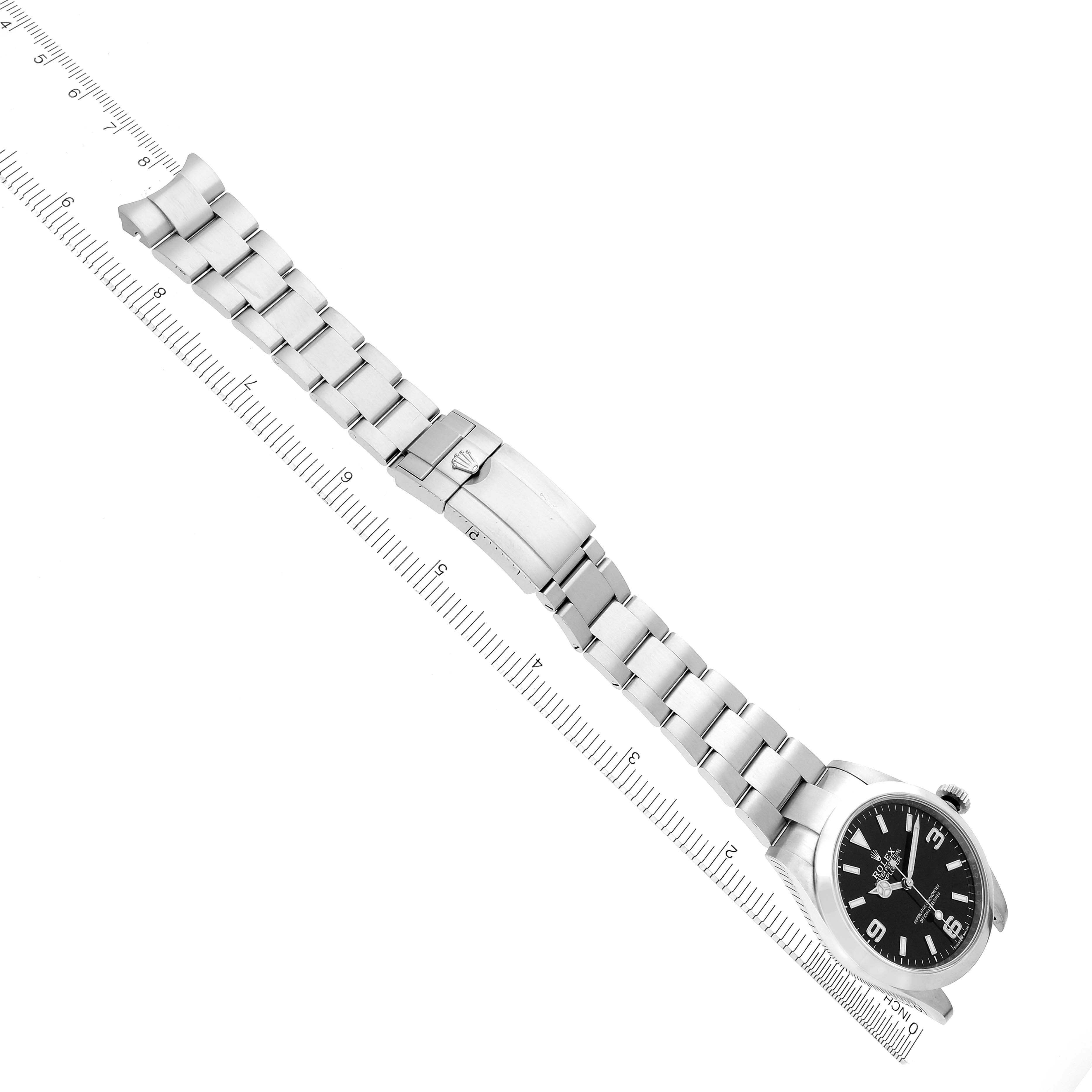 The Rolex Explorer 224270 Men's Stainless Steel Black Dial 224270 Men's Stainless Steel Black Dial watch is shown from a top view, displaying the full bracelet, clasp, and face alongside a ruler.