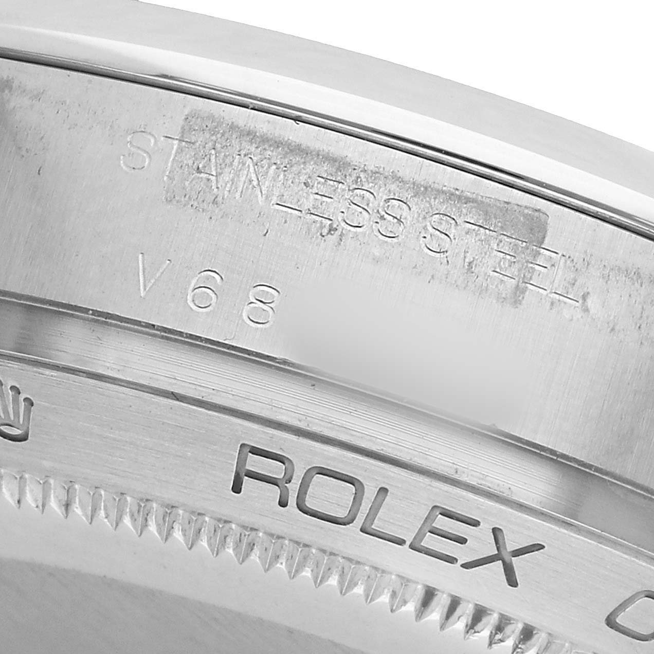 The image shows a close-up of the engraved case back edge of a Rolex Milgauss 116400 Men's Stainless Steel Black Dial, highlighting the "STAINLESS STEEL" text.