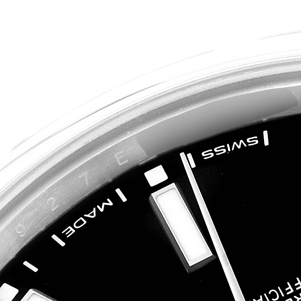 The image shows a close-up of the dial and a partially visible bezel of the Rolex Oyster Perpetual 114300 Men's Stainless Steel Black Dial 114300 Men's Stainless Steel Black Dial watch.