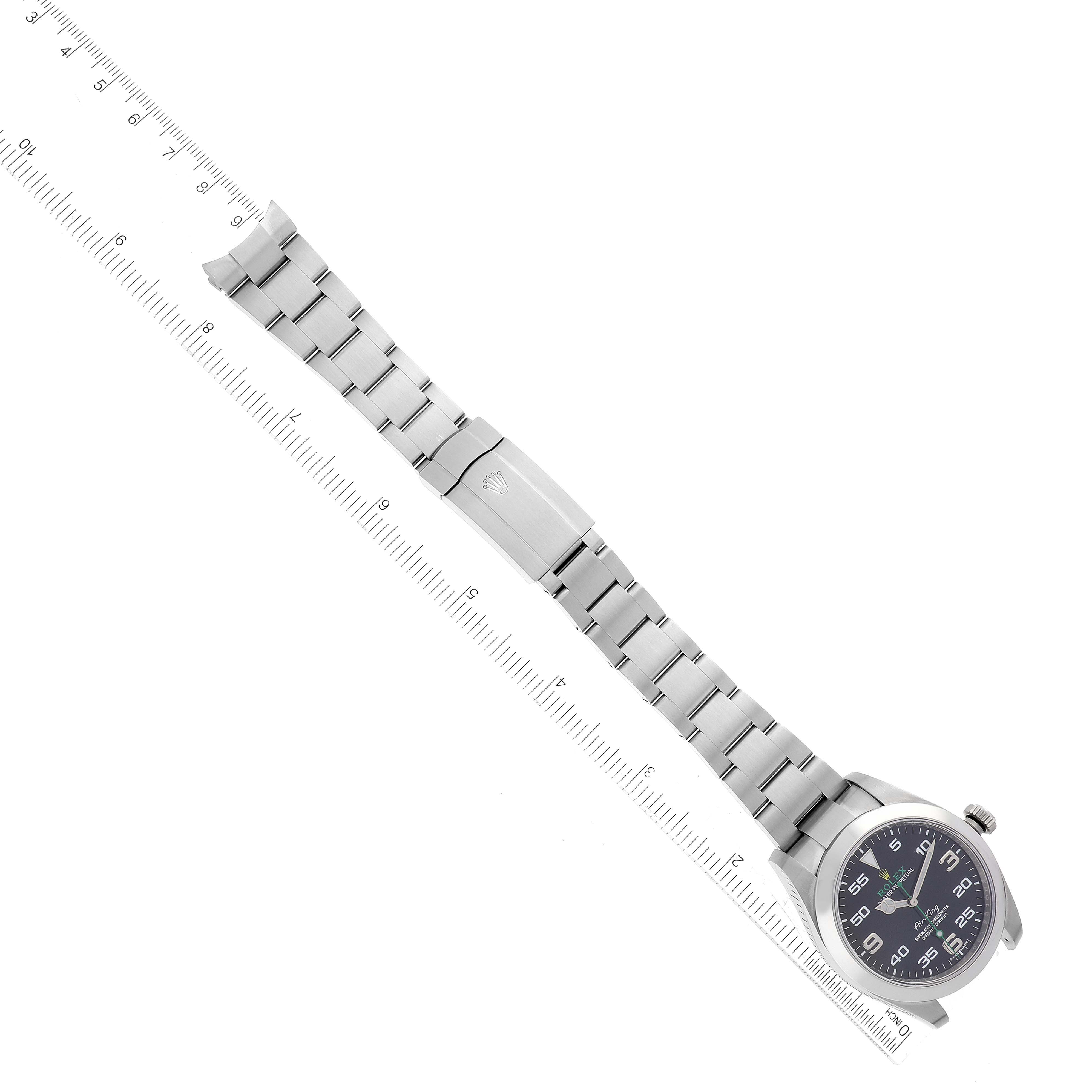 The image shows a top-down view of a Rolex Air-King 116900 Men's Stainless Steel Black Dial 116900 Men's Stainless Steel Black Dial watch, focusing on the face, bracelet, and clasp, with a ruler for scale.
