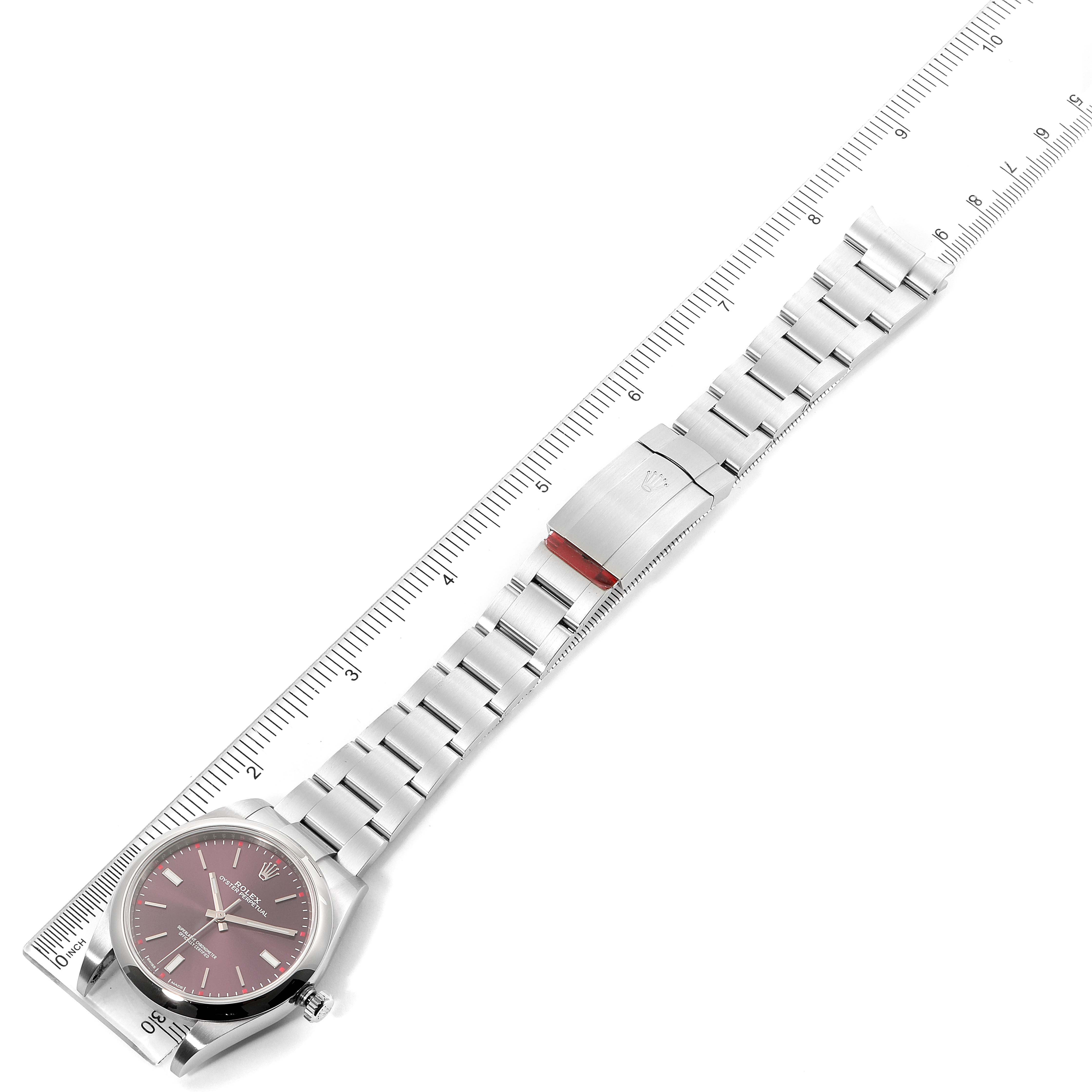 This image shows a Rolex Oyster Perpetual 114300 Men's Stainless Steel Burgundy Dial 114300 Men's Stainless Steel Burgundy Dial watch with a silver bracelet, measured against a ruler.