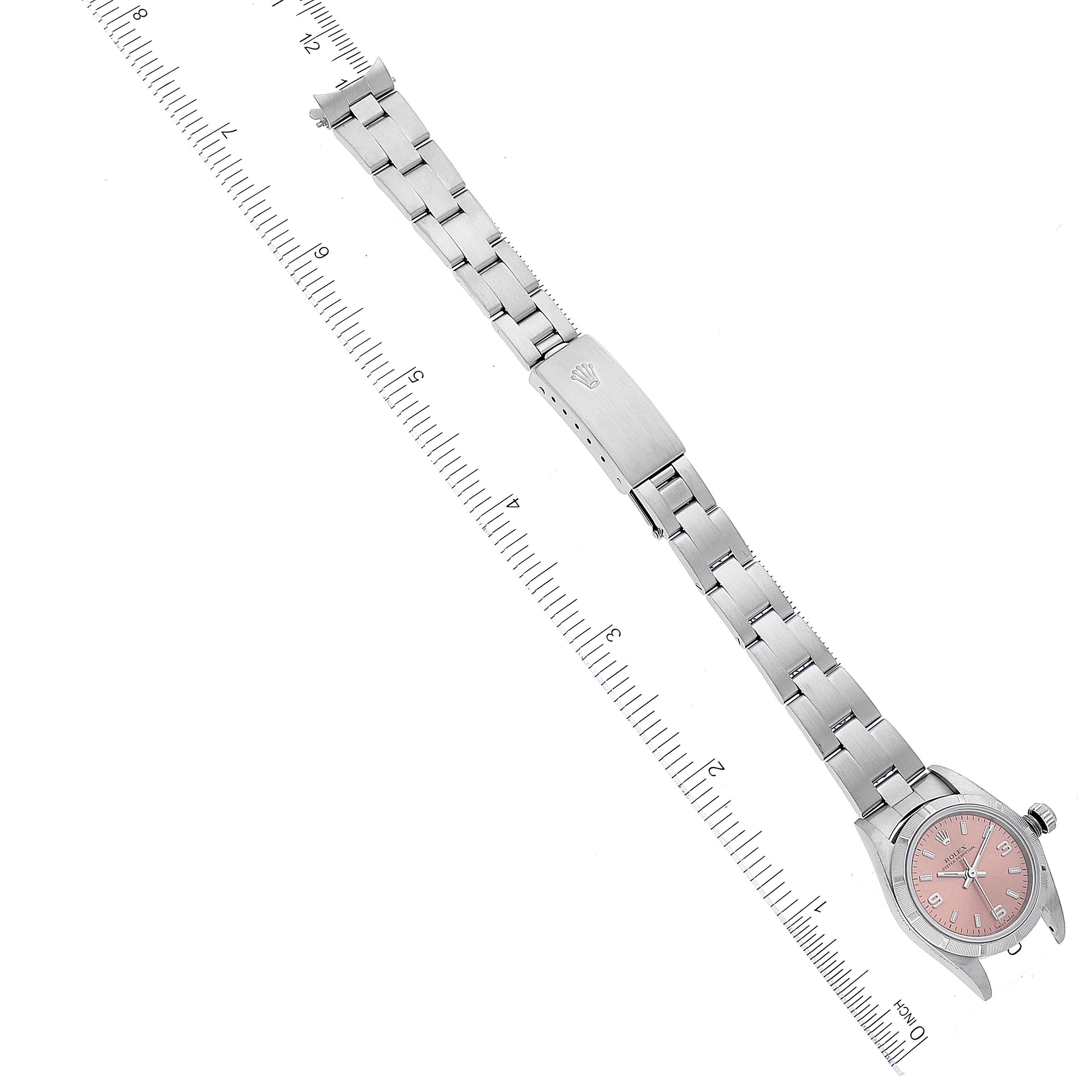 This image shows a Rolex Oyster Perpetual 76030 Women's Stainless Steel Pink Dial 76030 Women's Stainless Steel Pink Dial watch laid flat with its bracelet extended alongside a ruler for size reference.