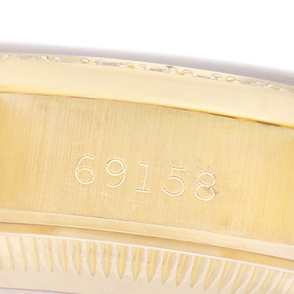 This image shows a close-up of the case side of the Rolex President 69158 Women's Yellow Gold Champagne Dial watch model, including engraved numbers.